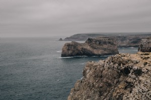 Le scogliere rocciose rotolano indietro dal freddo mare grigio foto 