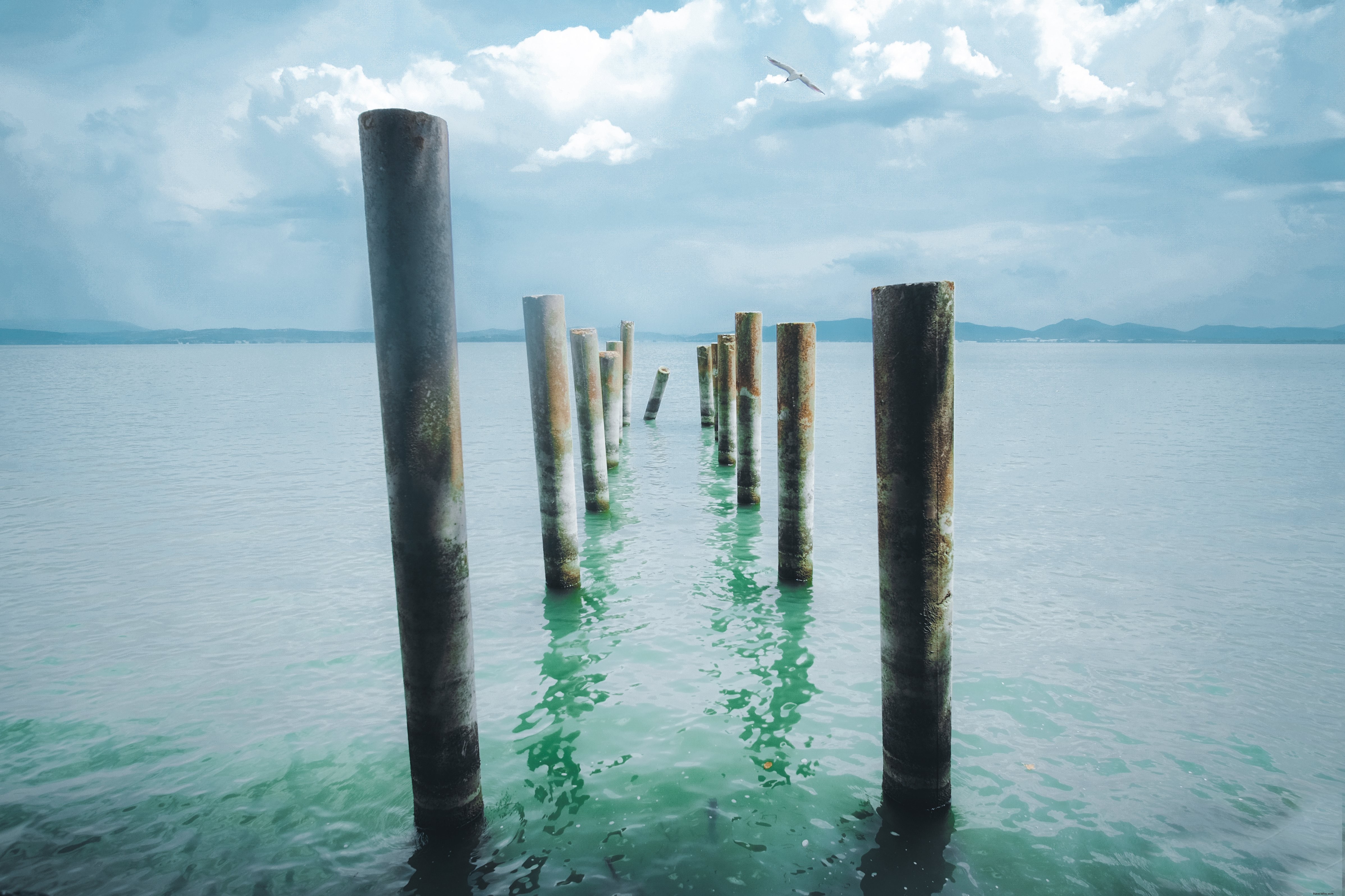 I pioli di legno conducono nell acqua blu acqua foto 