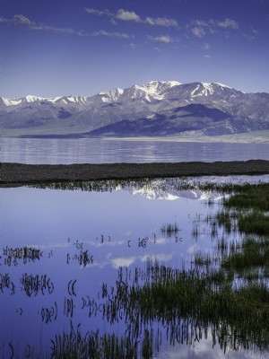 Montanhas refletidas no lago abaixo da foto 