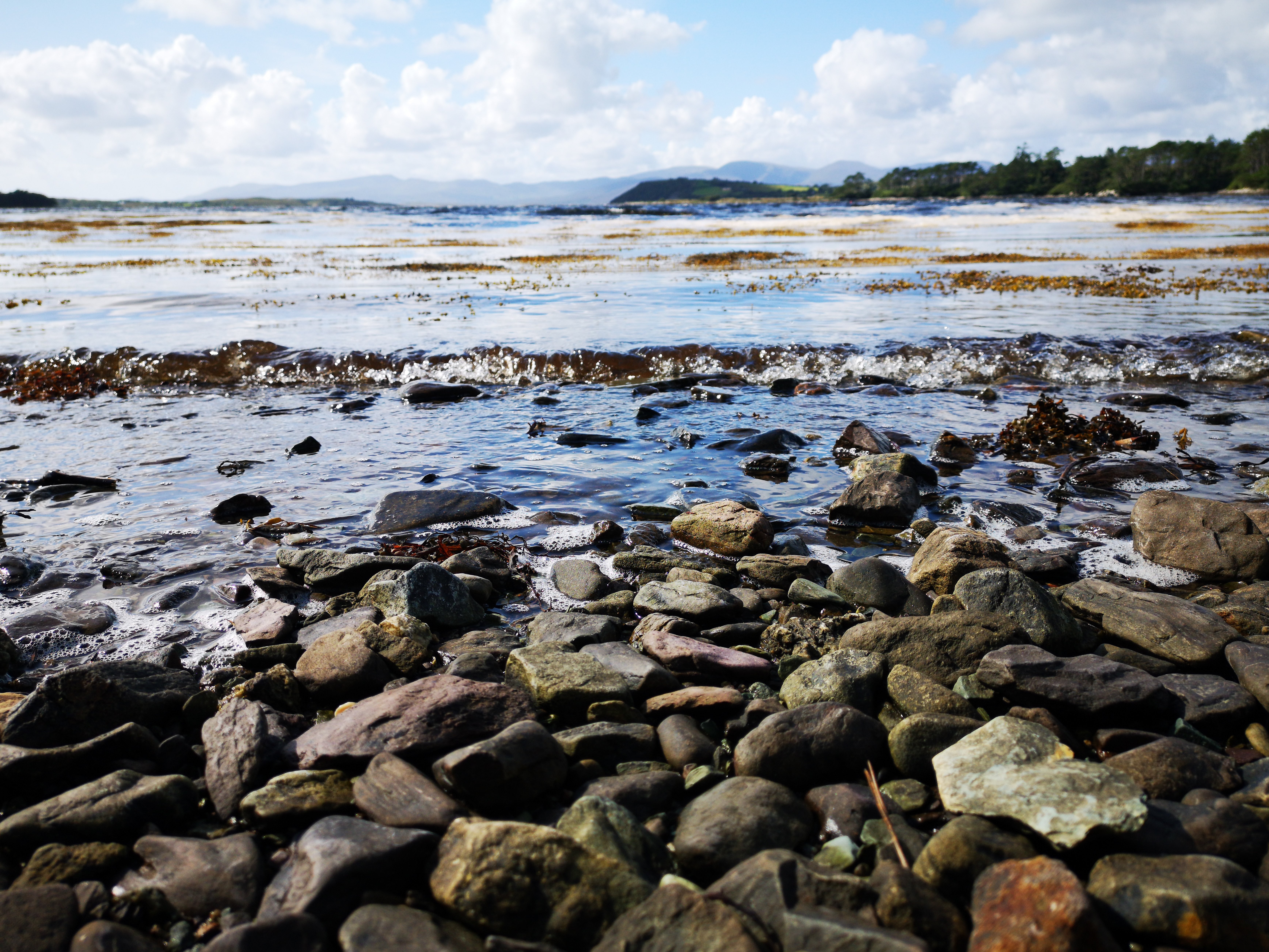 Les vagues bullent sur les pierres de la berge Photo 