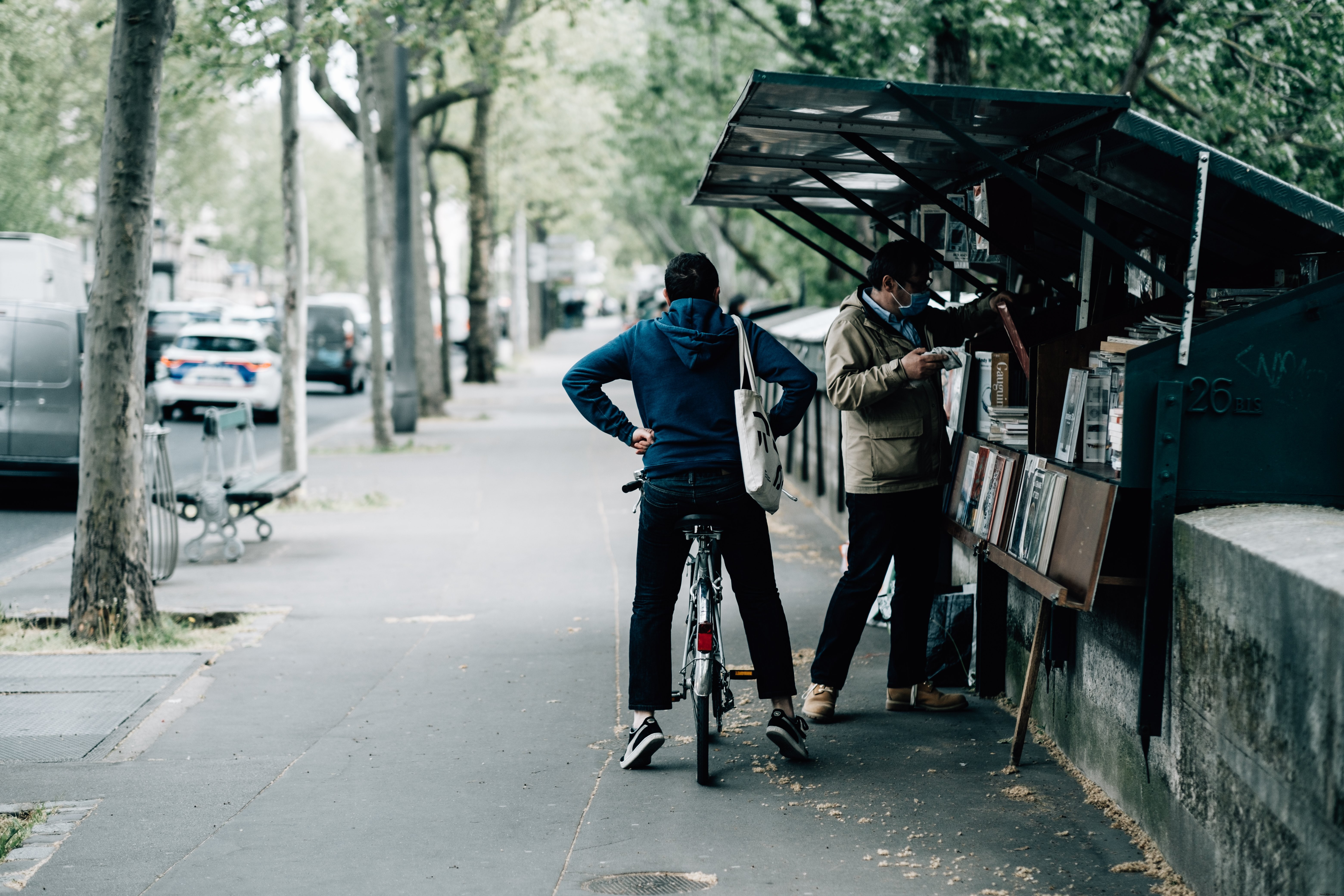 自転車に乗っている人は、友達が本を買うのを待っています写真 