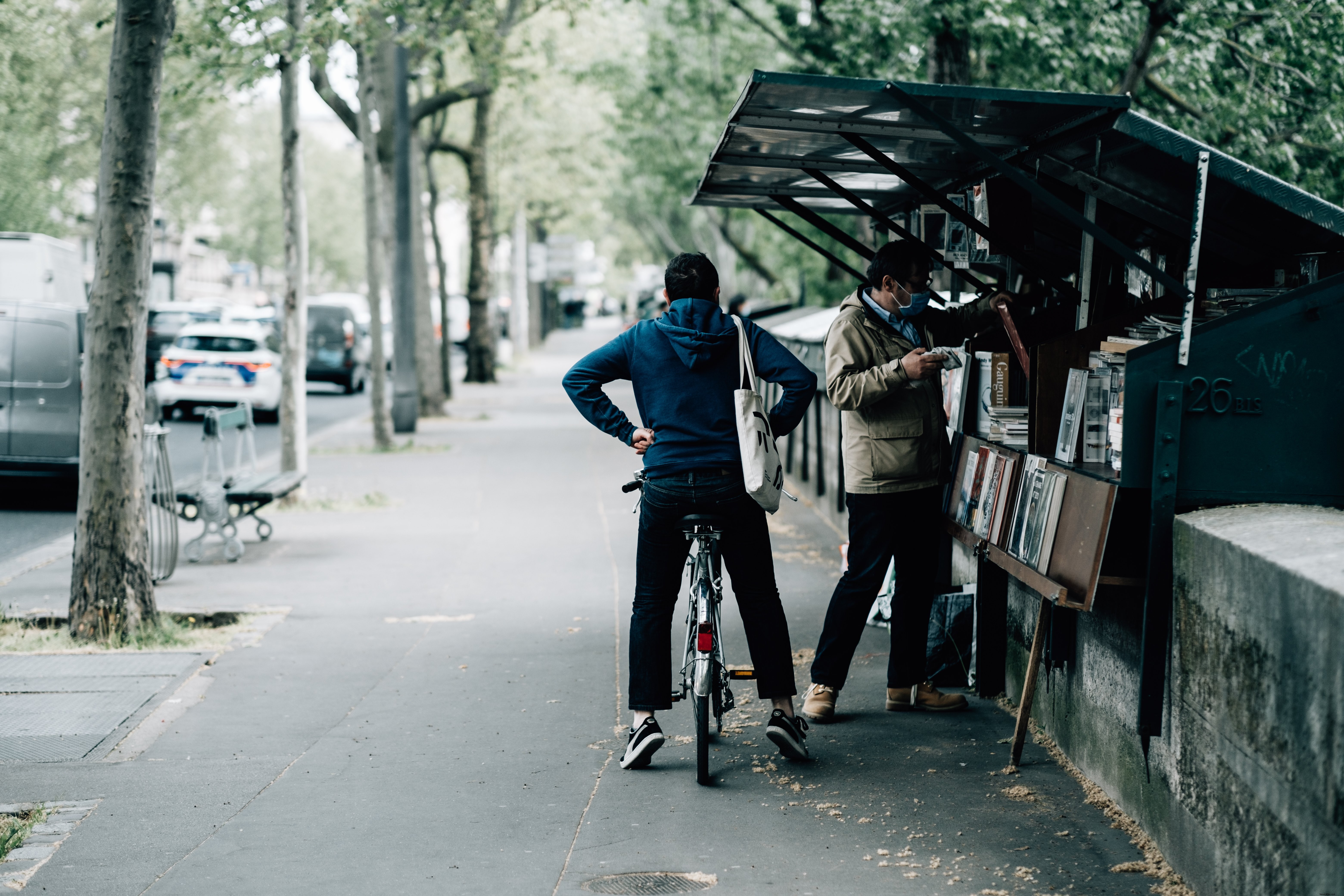 Persona en bicicleta espera a que su amigo compre libros. 