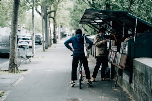 Persona en bicicleta espera a que su amigo compre libros. 