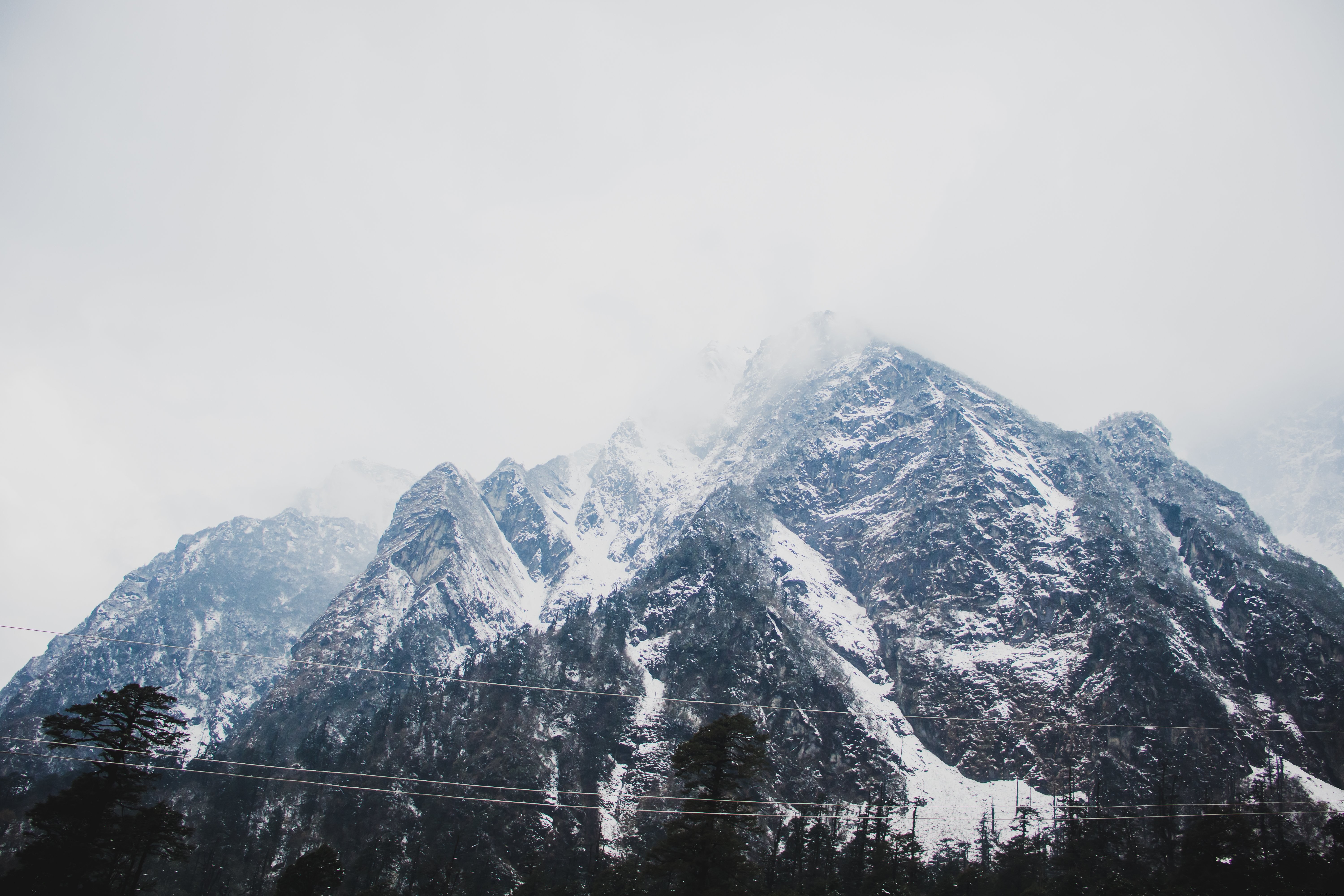 Pegunungan yang Tertutup Salju Ditutupi Dengan Awan Foto 