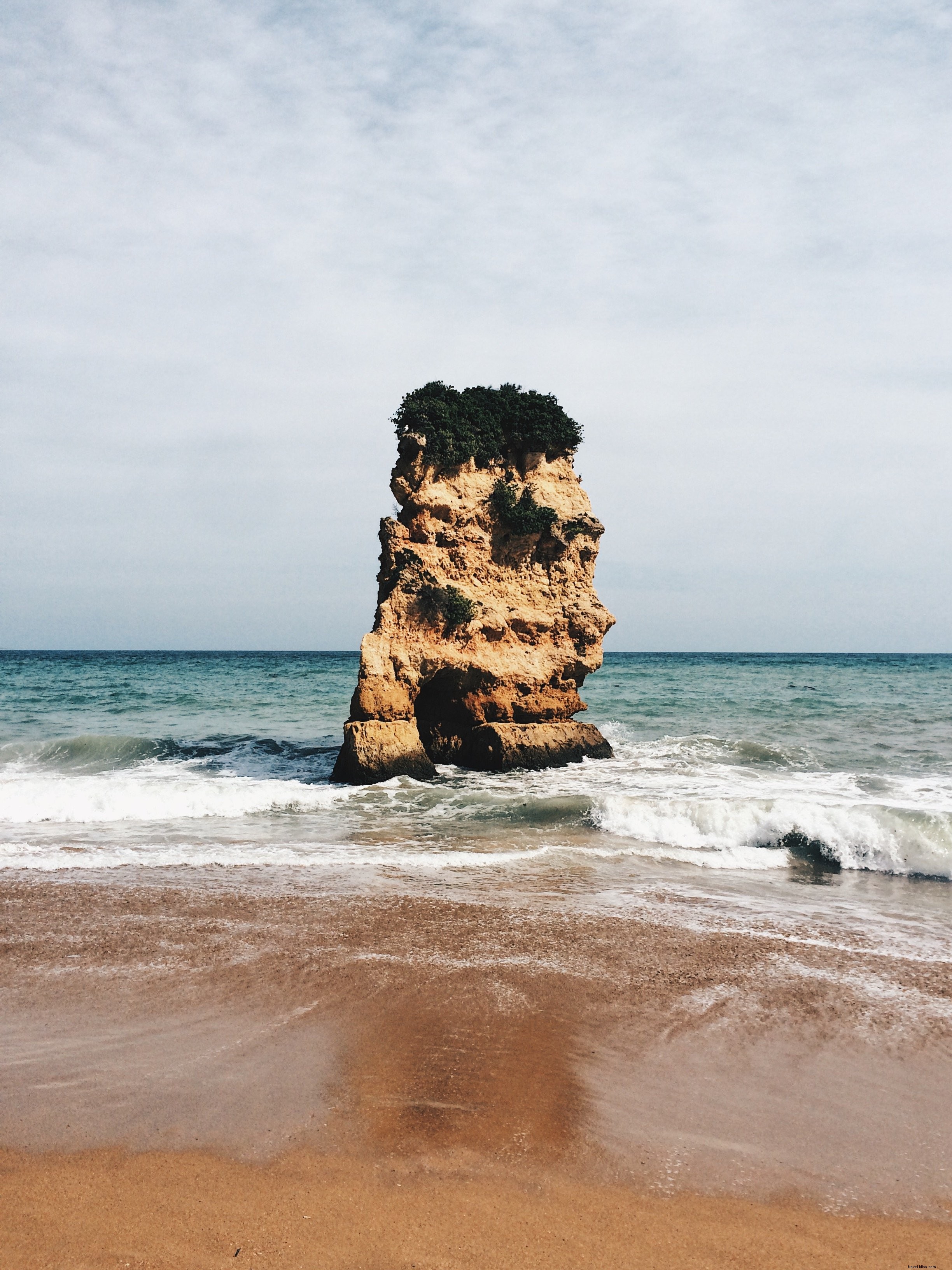 Una gran roca hace guardia en medio del océano Foto 