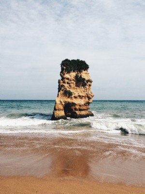 Una gran roca hace guardia en medio del océano Foto 