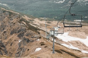 Foto:Elevador de cadeira sobre colina com remendos de neve 