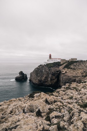 Un phare veille sur une photo de la côte rocheuse 