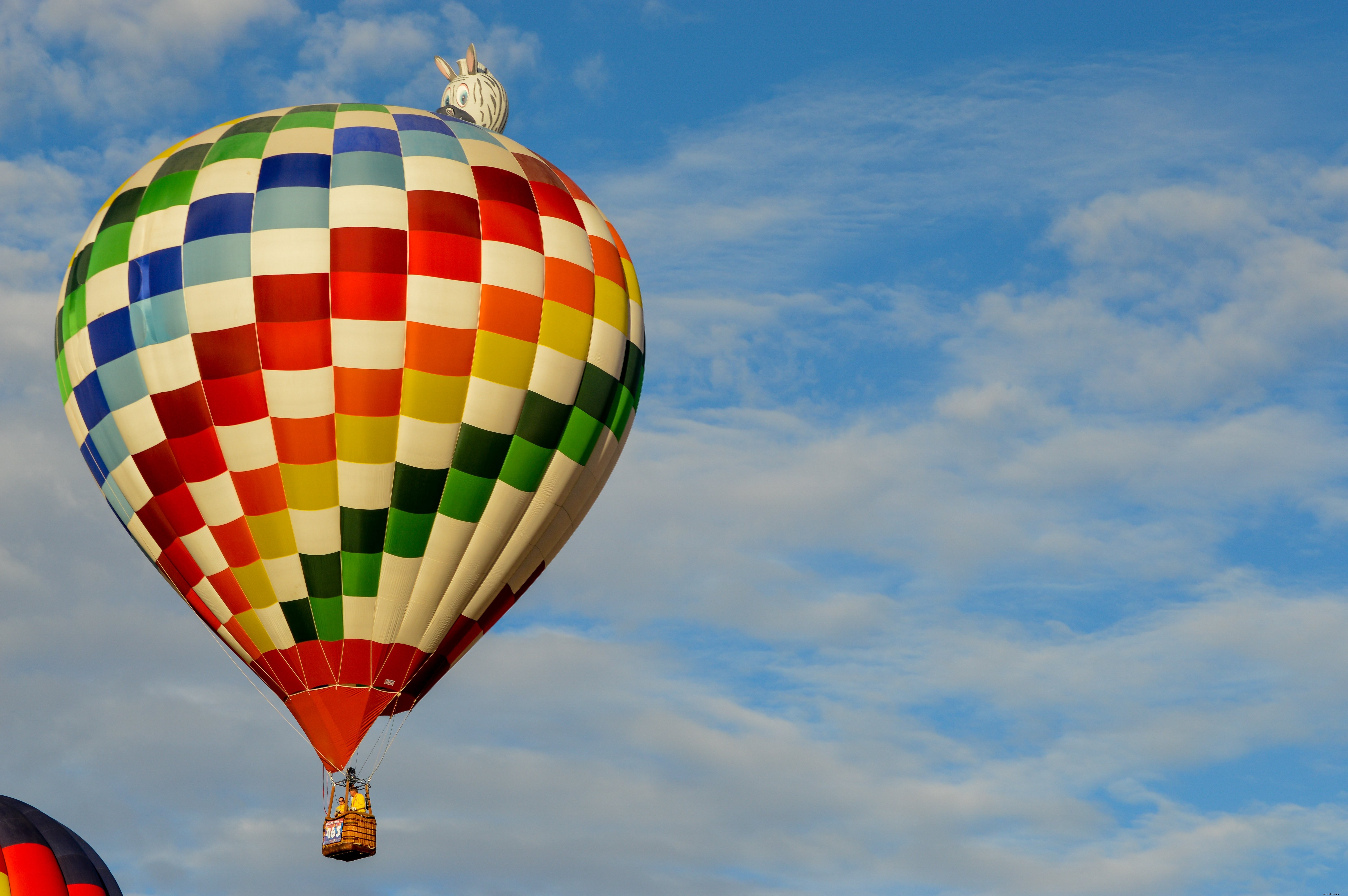 Balão de ar quente colorido voa contra uma foto de céu azul 