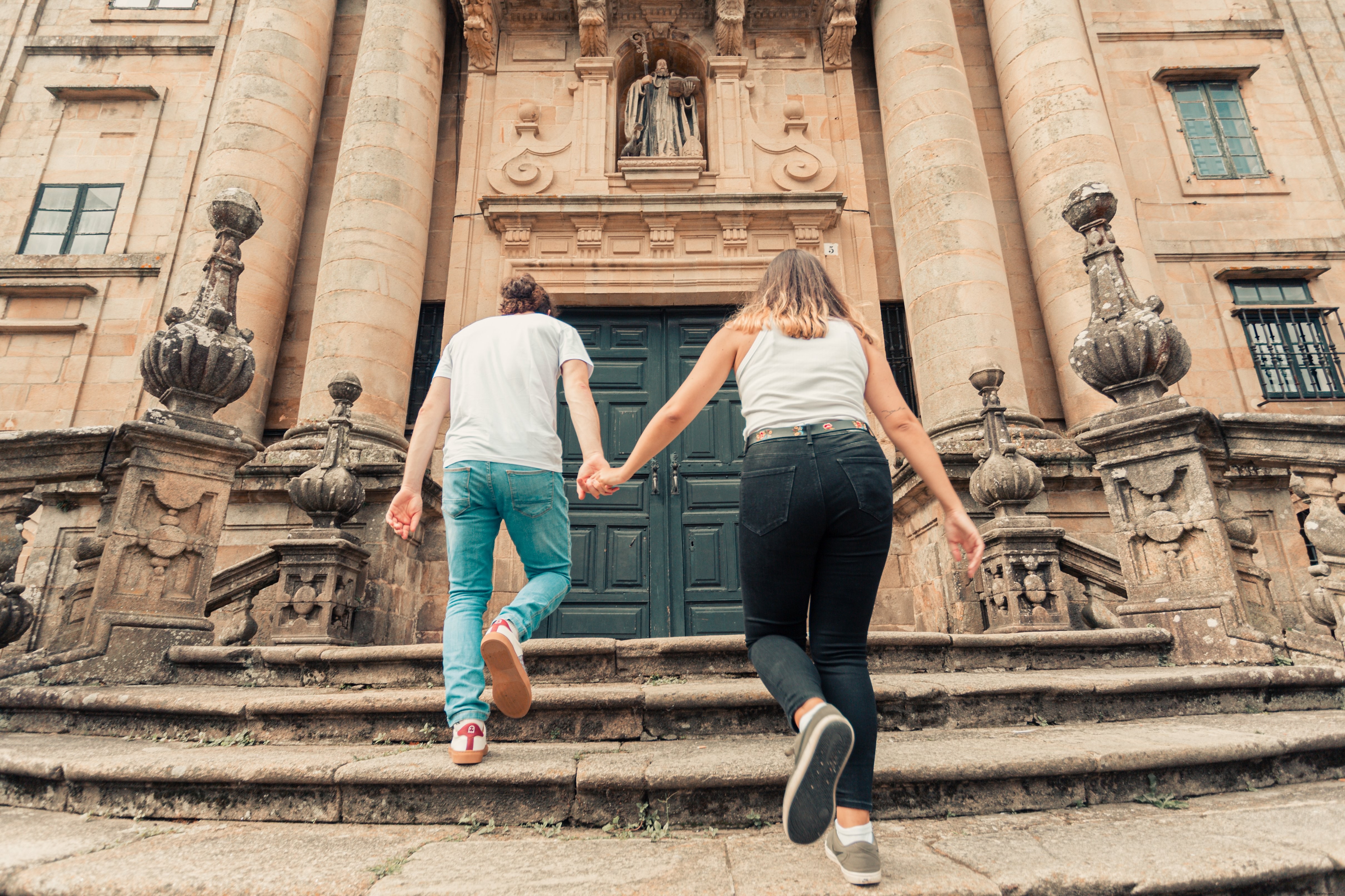 Couple se tient la main en marchant sur les marches de pierre Photo 