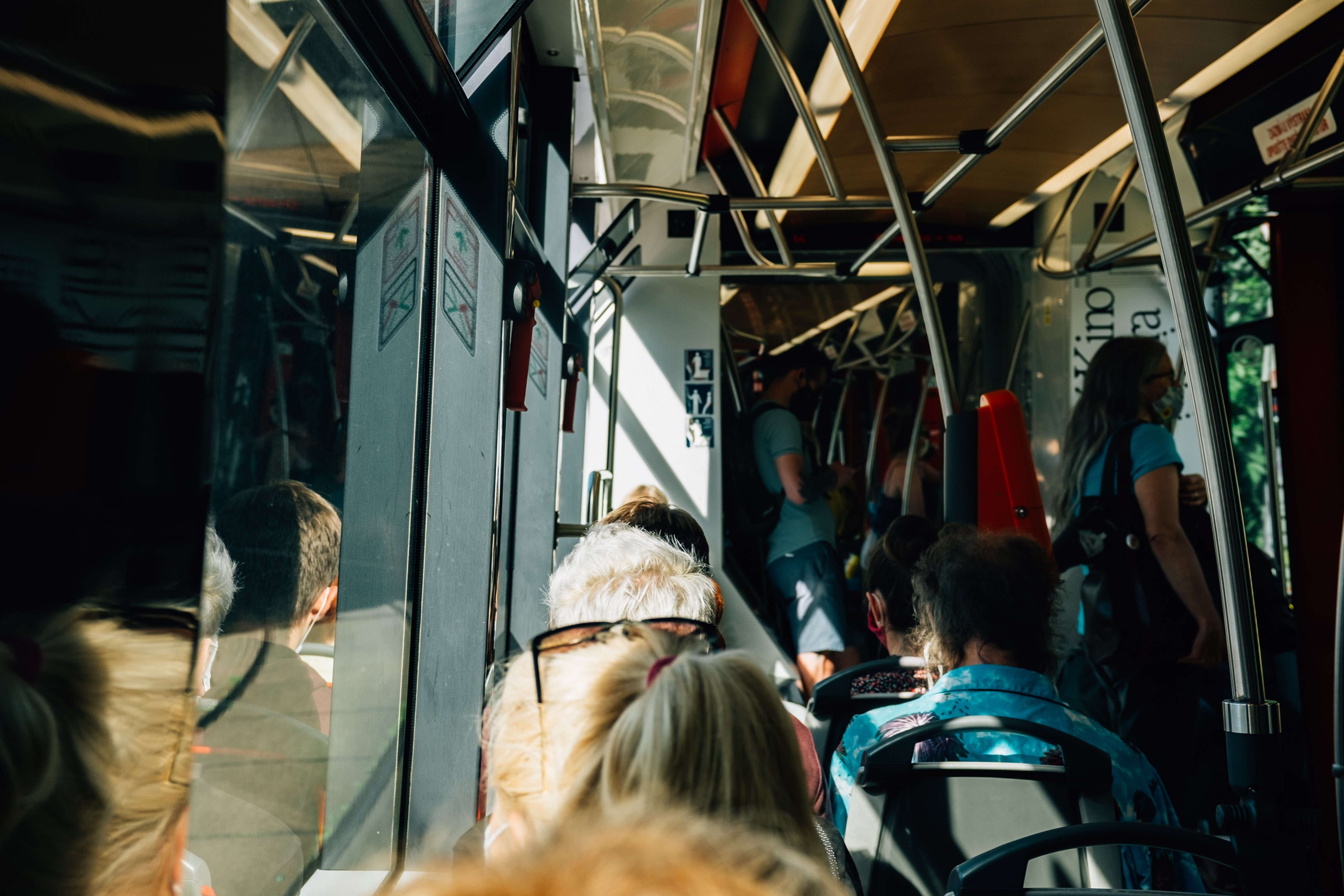 Foto de um vagão de trem de transporte público cheio de pessoas 