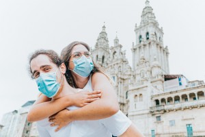Mulher abraça um homem por trás enquanto usa uma máscara azul - foto 