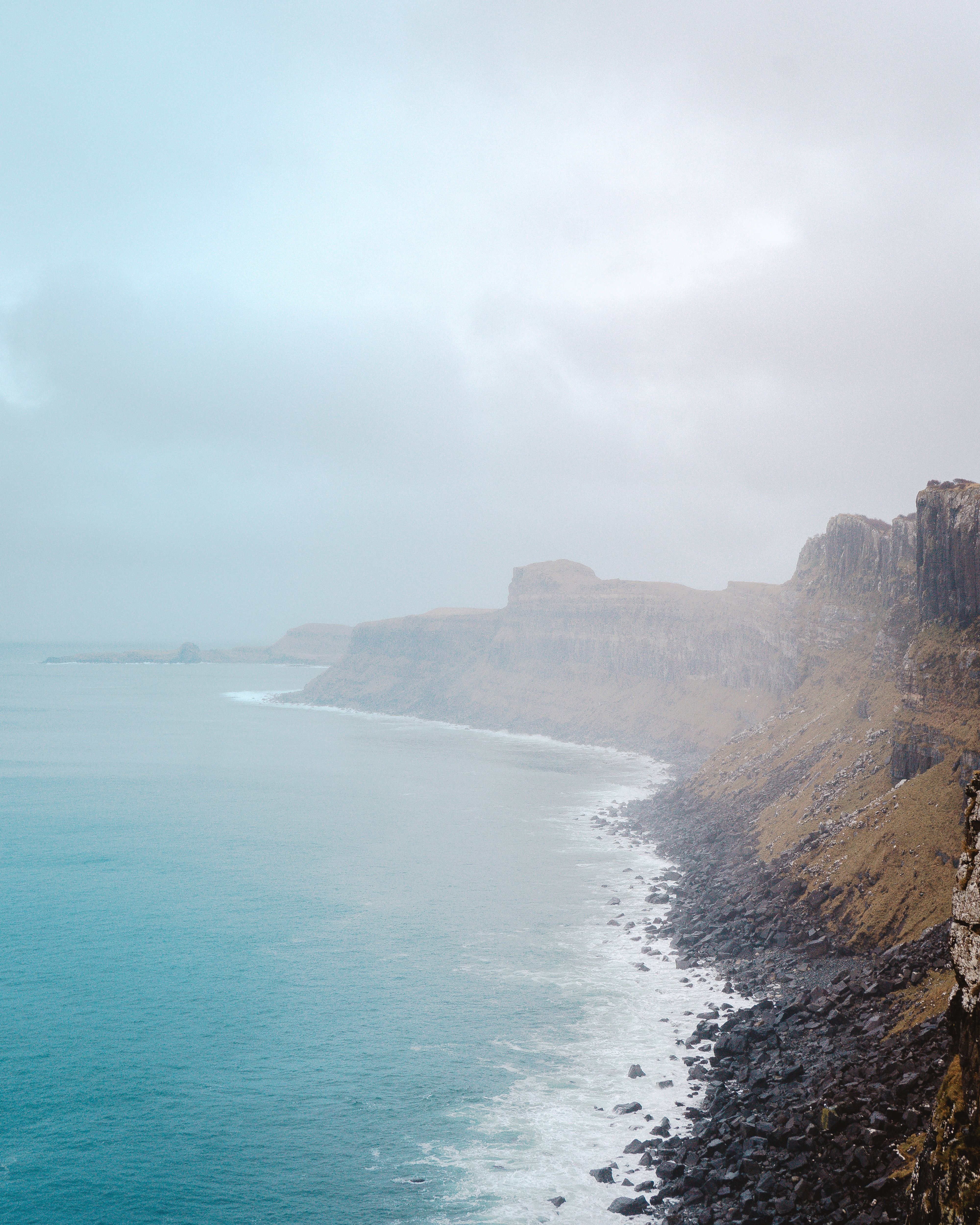 Foto de acantilados y rocas negras y vista al mar 