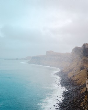 Foto de acantilados y rocas negras y vista al mar 