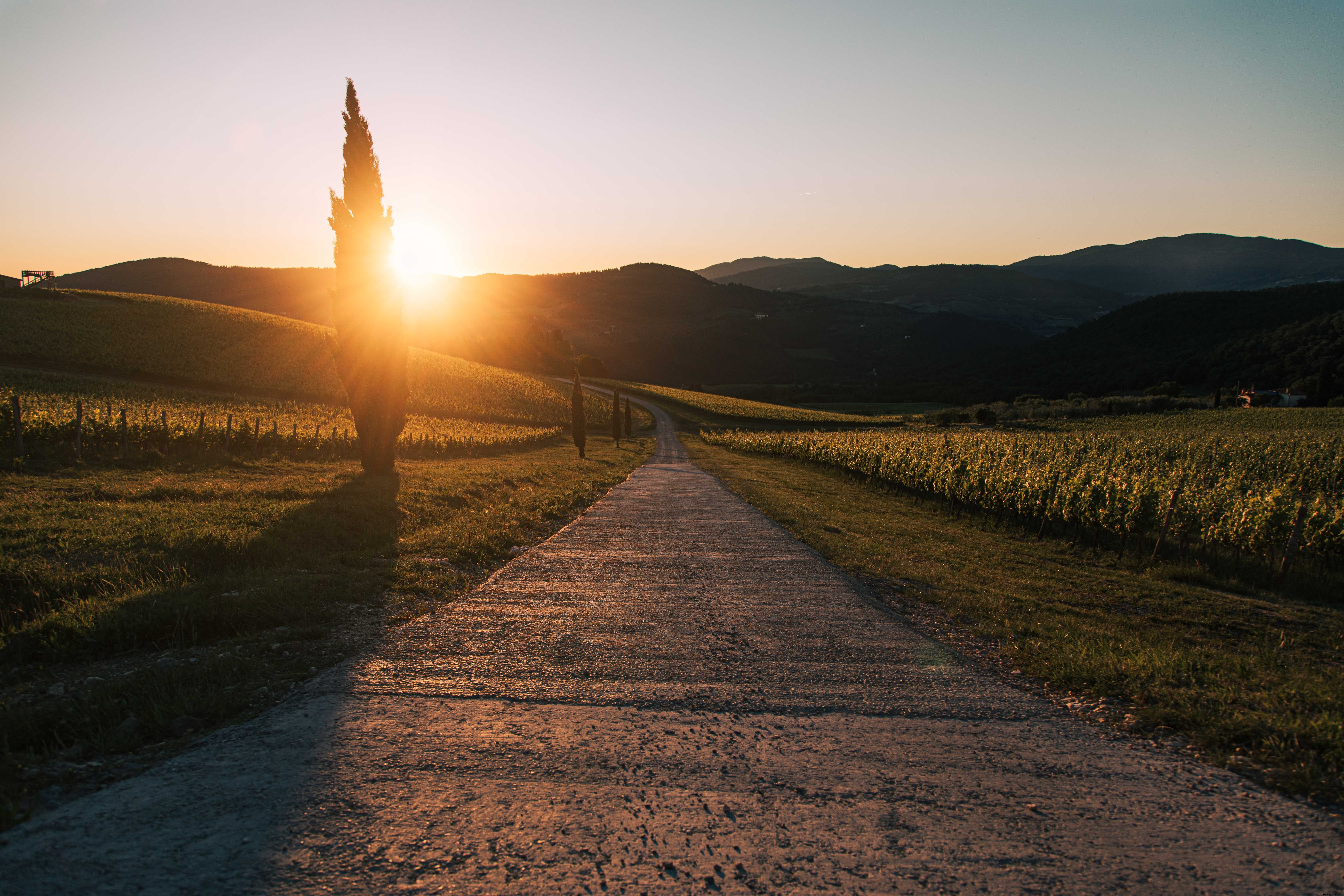 Foto de estrada através de montanhas sob o sol poente 