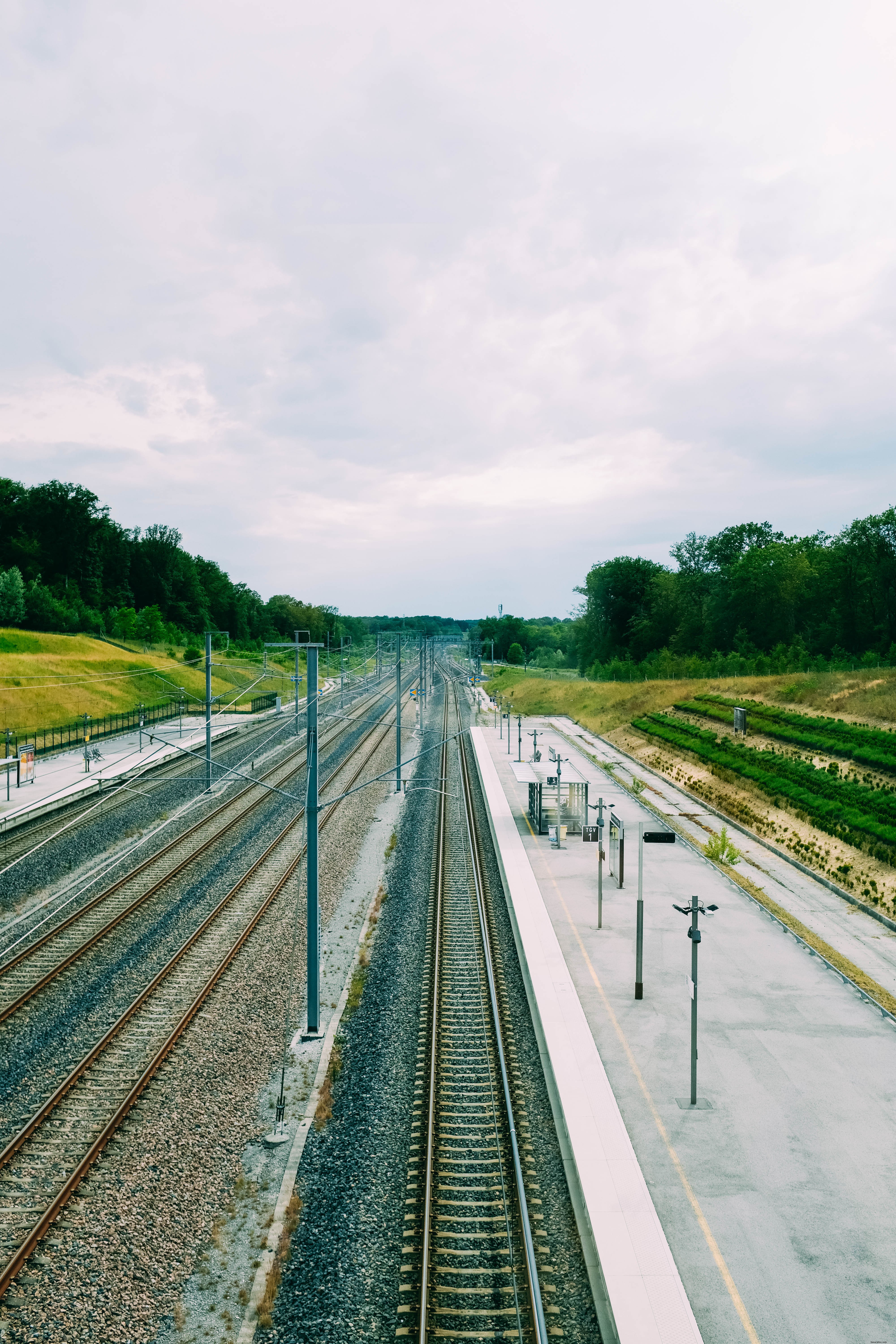 Trilhos de trem nus ao lado de uma foto de plataforma vazia 