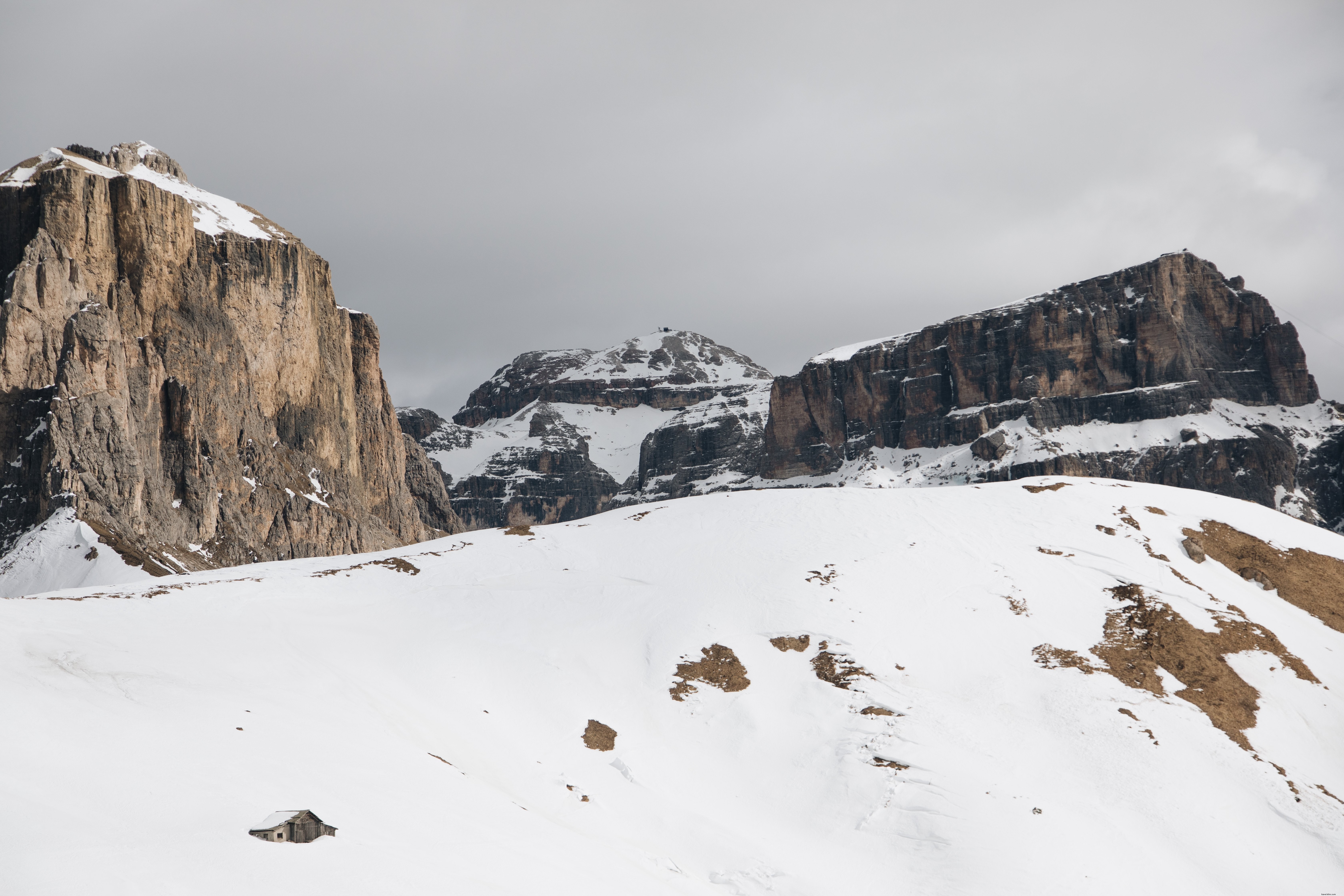 Foto de paisagem montanhosa rochosa cercada por neve 