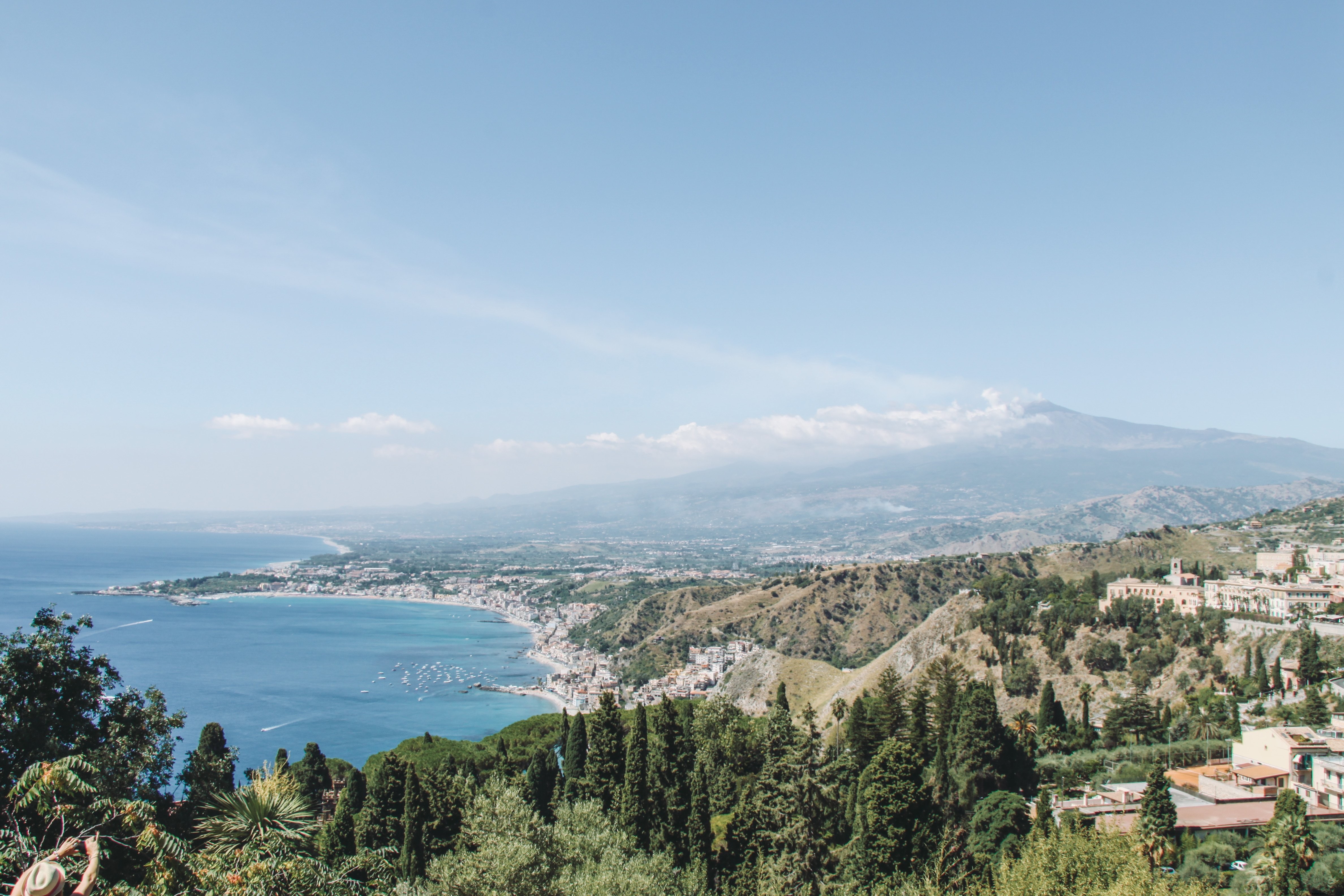 Foto de la costa soleada debajo de las montañas distantes 