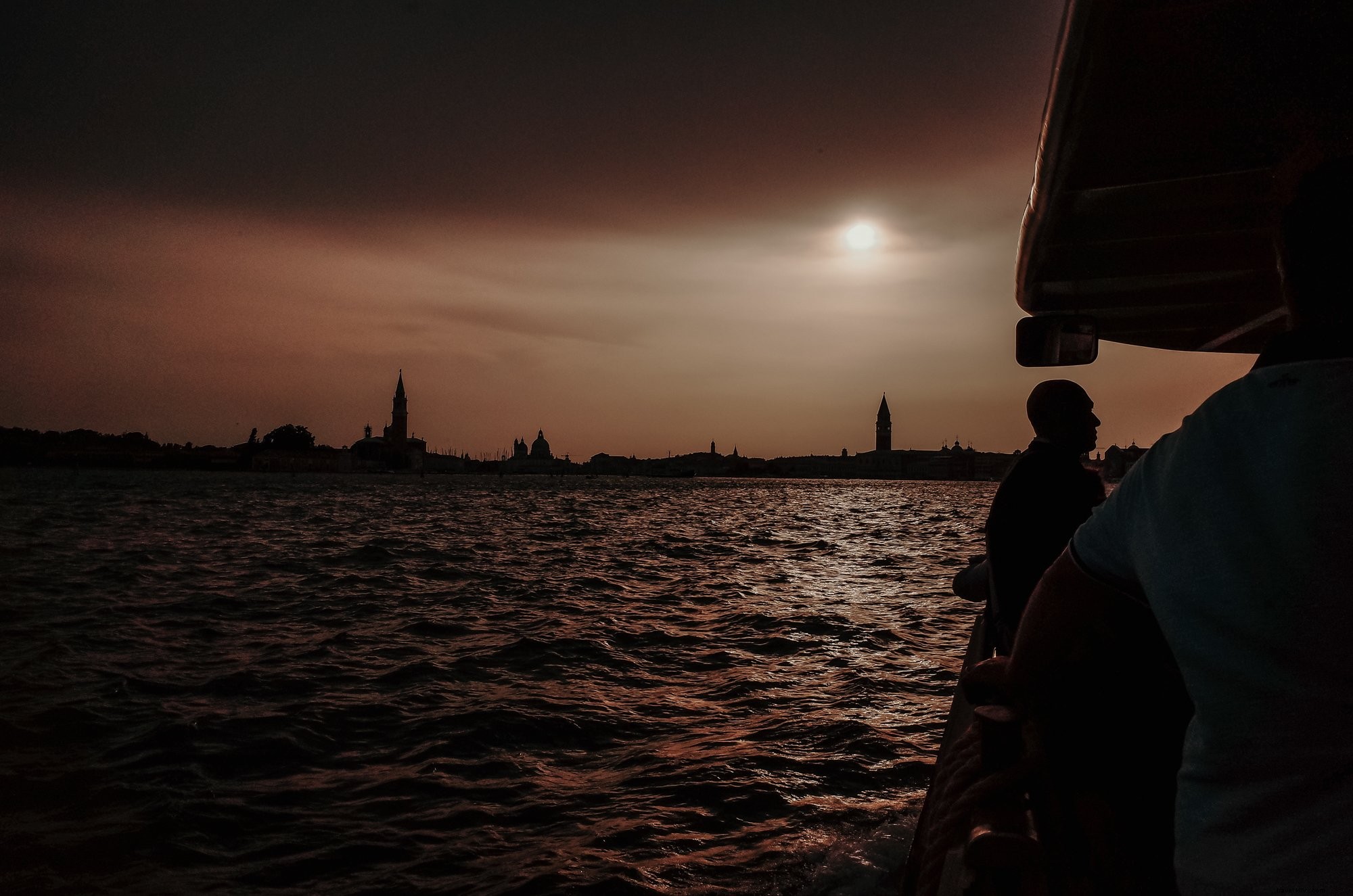 Paseo en barco por la noche sobre aguas onduladas junto a la foto de la ciudad 