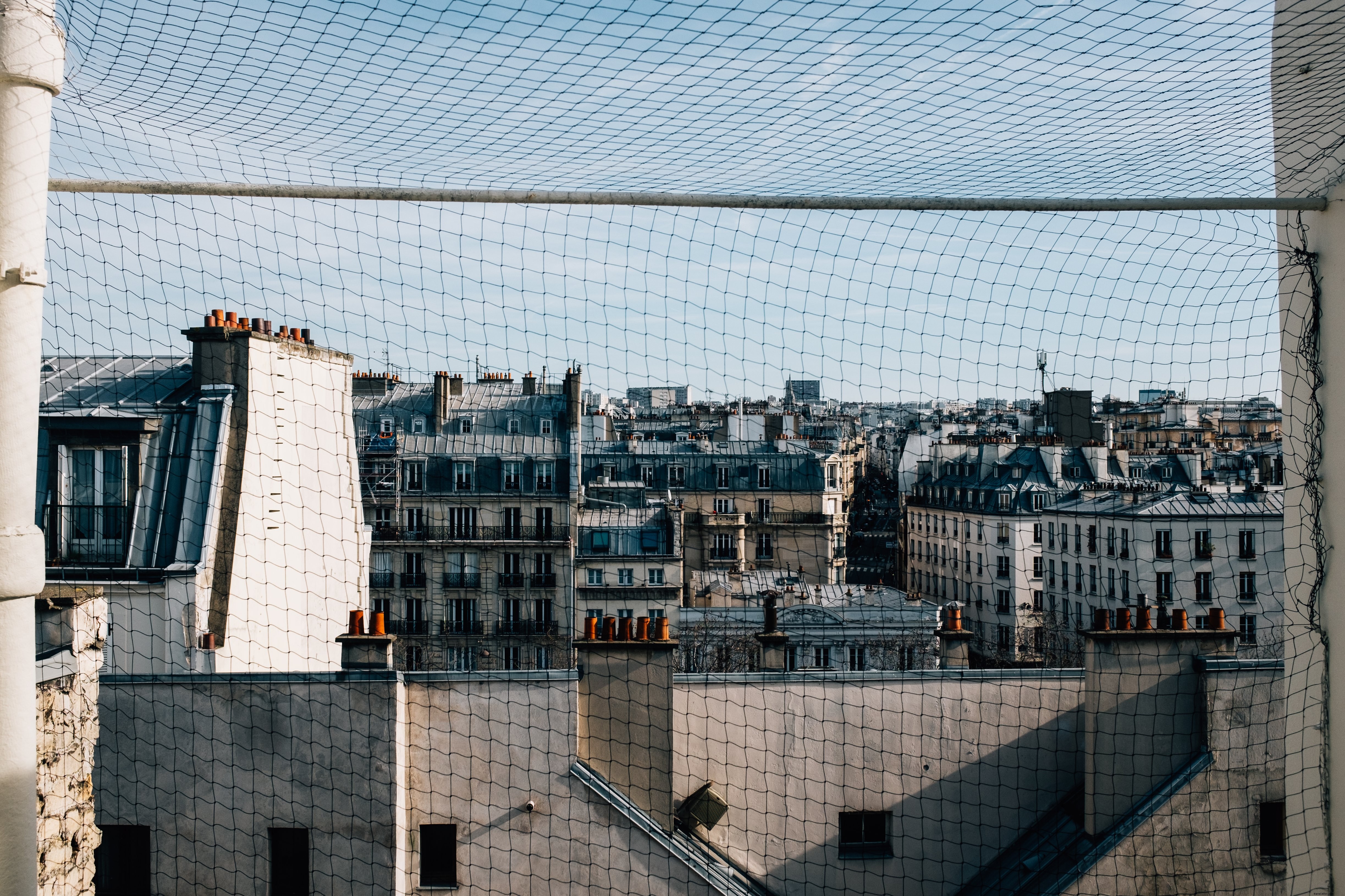 Bâtiments blancs vus à travers une photo de clôture métallique 