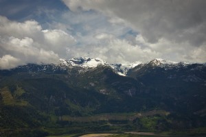 Montañas Verdes Cubiertas De Nieve Bajo Nubes Esponjosas Foto 