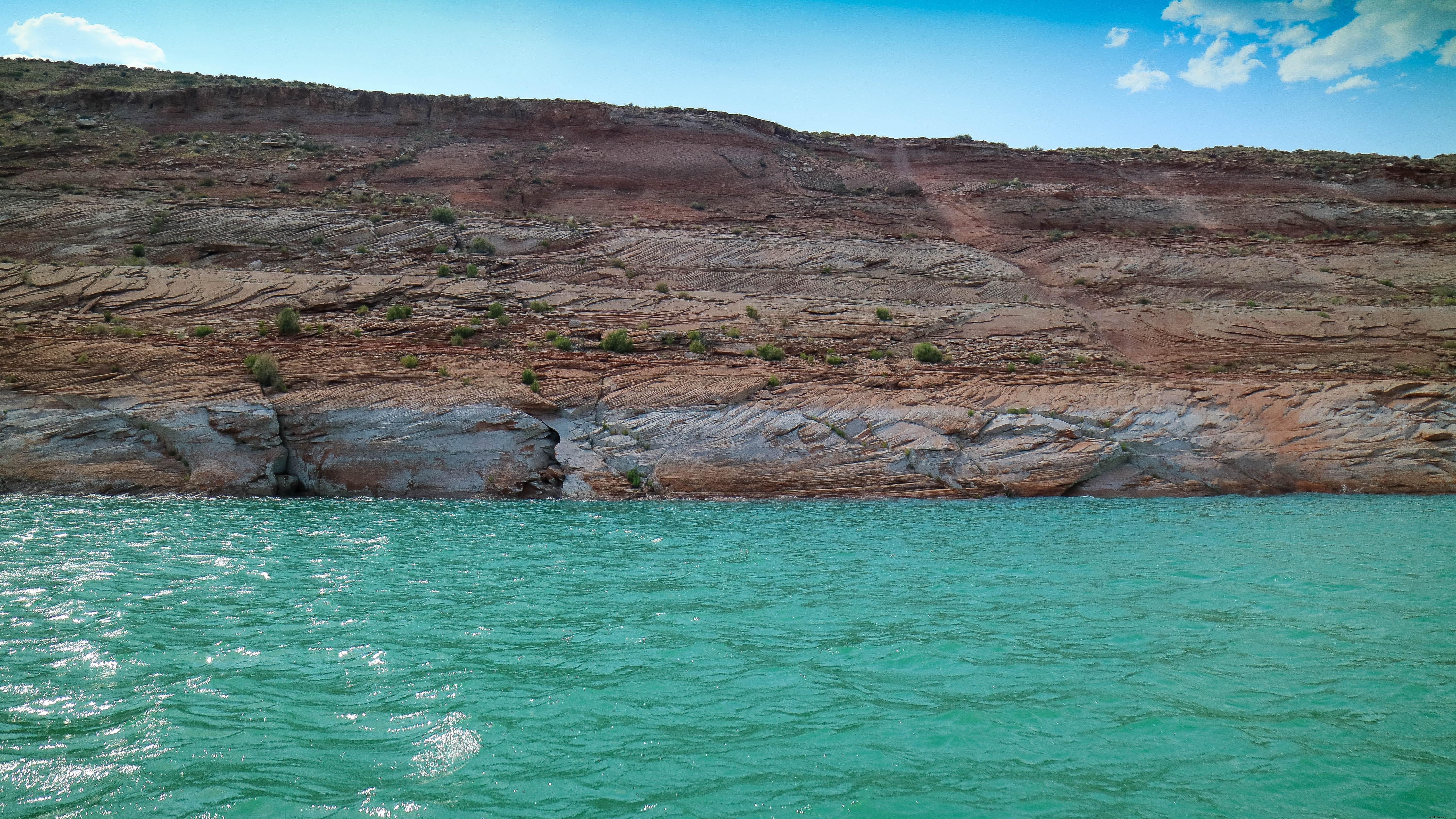 崖の端の写真の下の鮮やかなアクアブルーの水 
