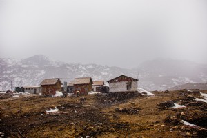 Cabañas en una colina marrón con nieve suave que cae Foto 
