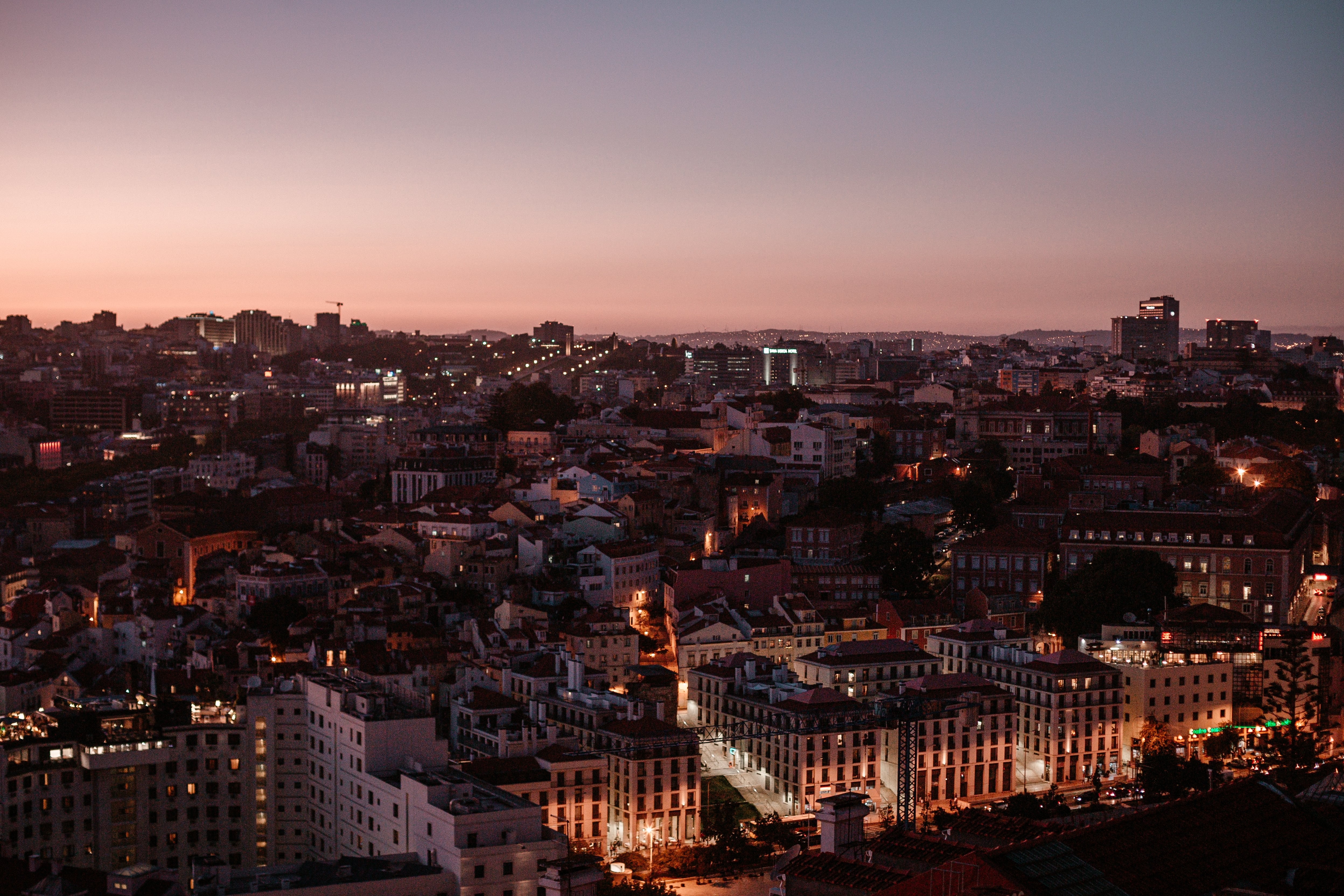 Vista aérea del horizonte de la ciudad con puesta de sol rosa detrás de la foto 