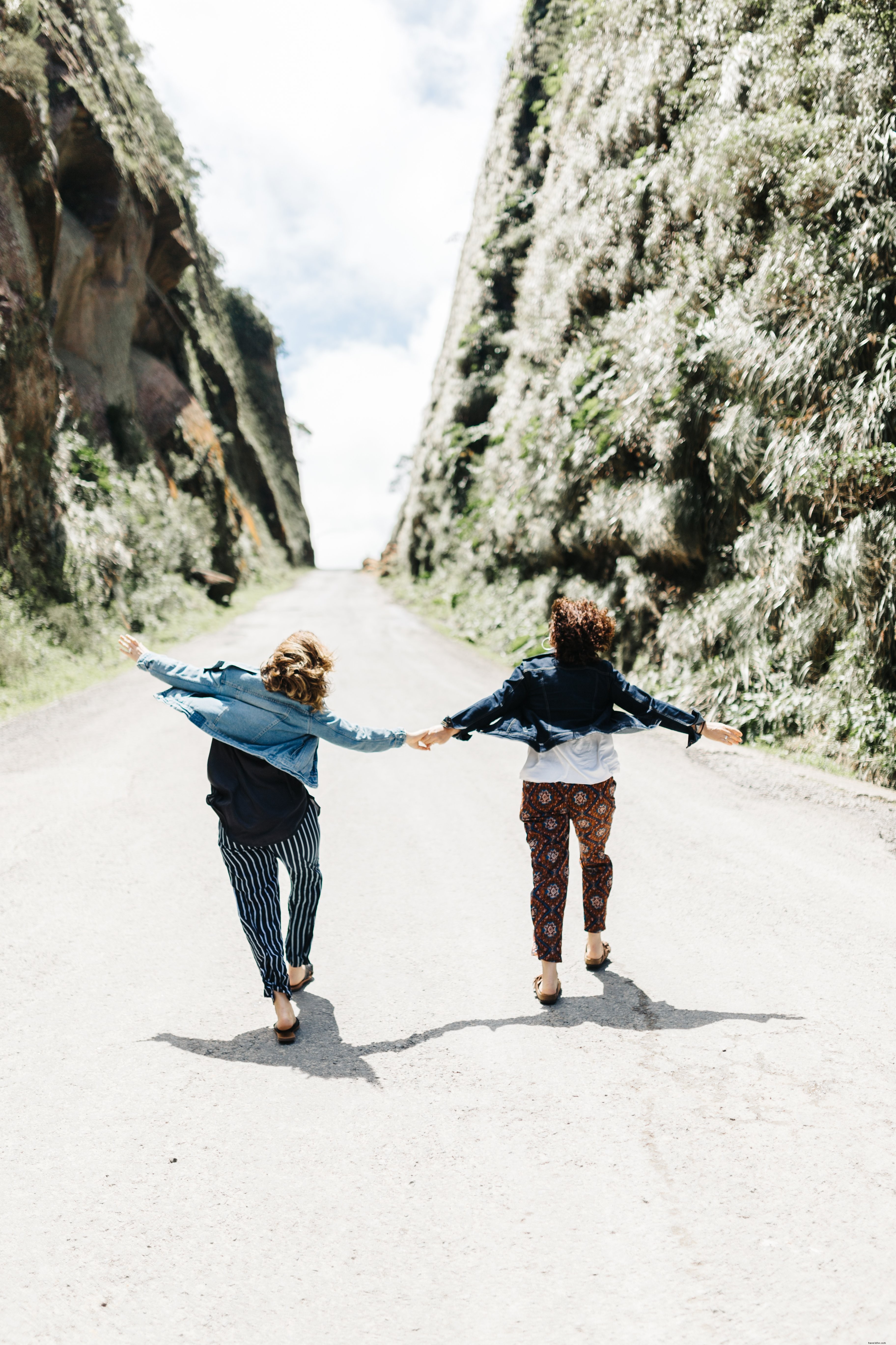 Duas pessoas de mãos dadas enquanto sobem na estrada. Foto 