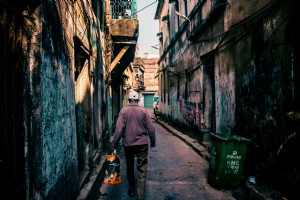 Foto de pessoa caminhando em um beco coberto de grafite 