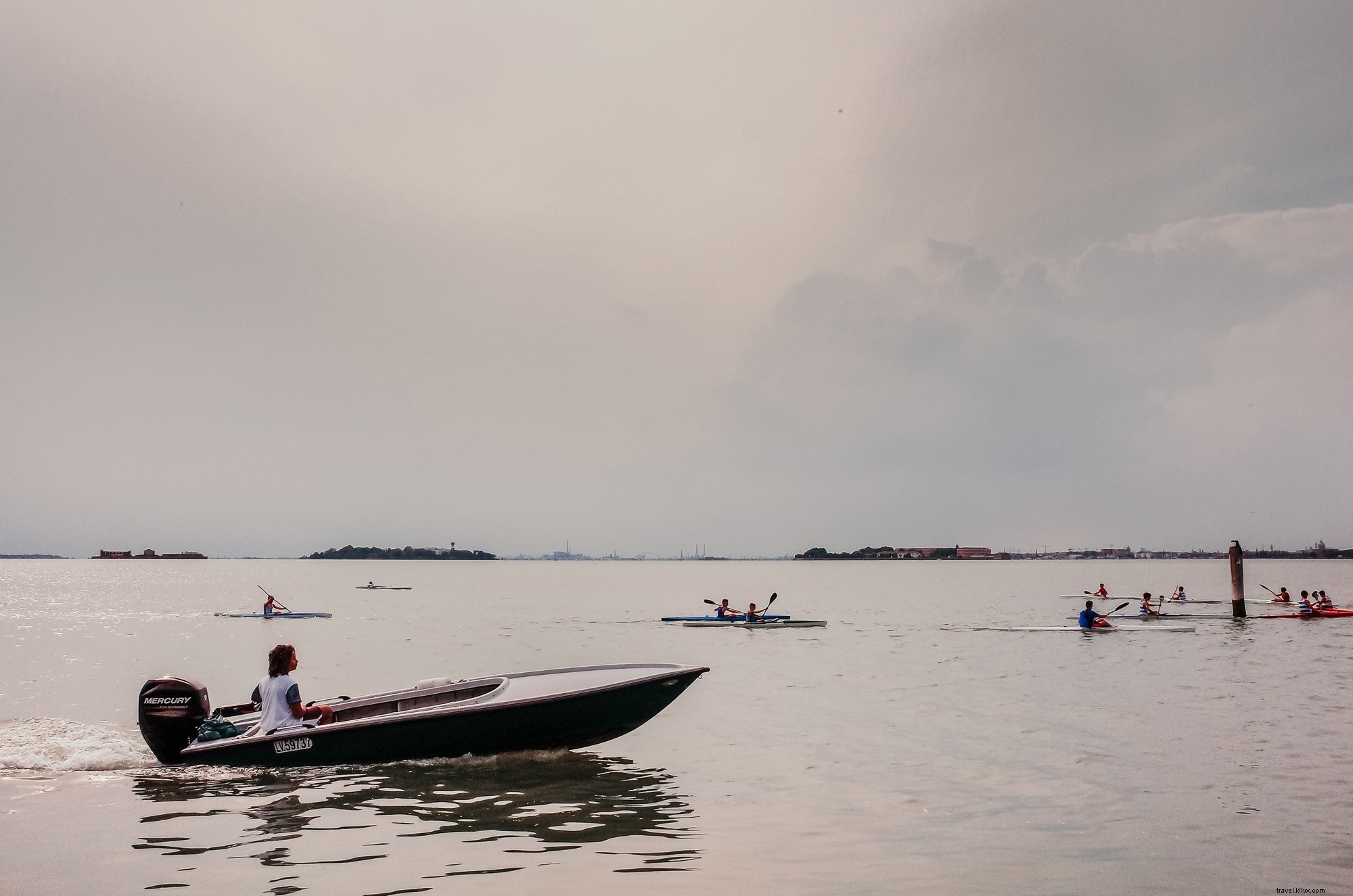 Persone in kayak in una giornata nuvolosa con una barca dopo la foto 