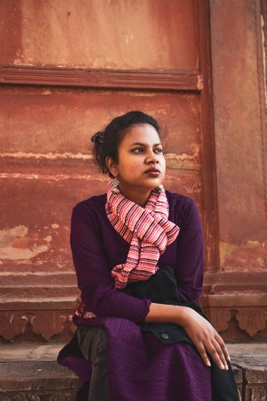 Portrait d une personne assise près d un mur de couleur rouille Photo 