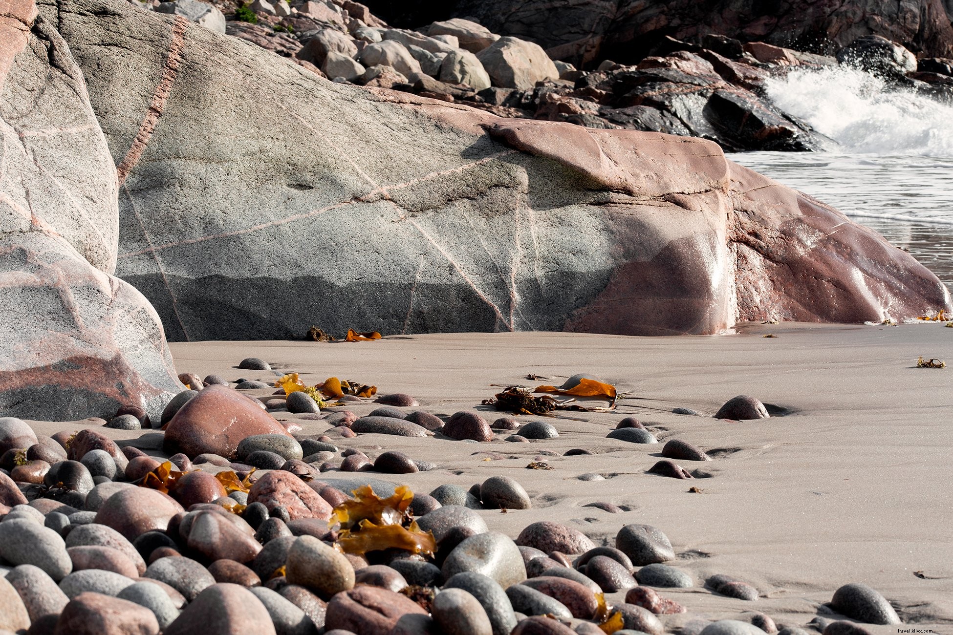 Foto da praia rochosa encharcada de sol 