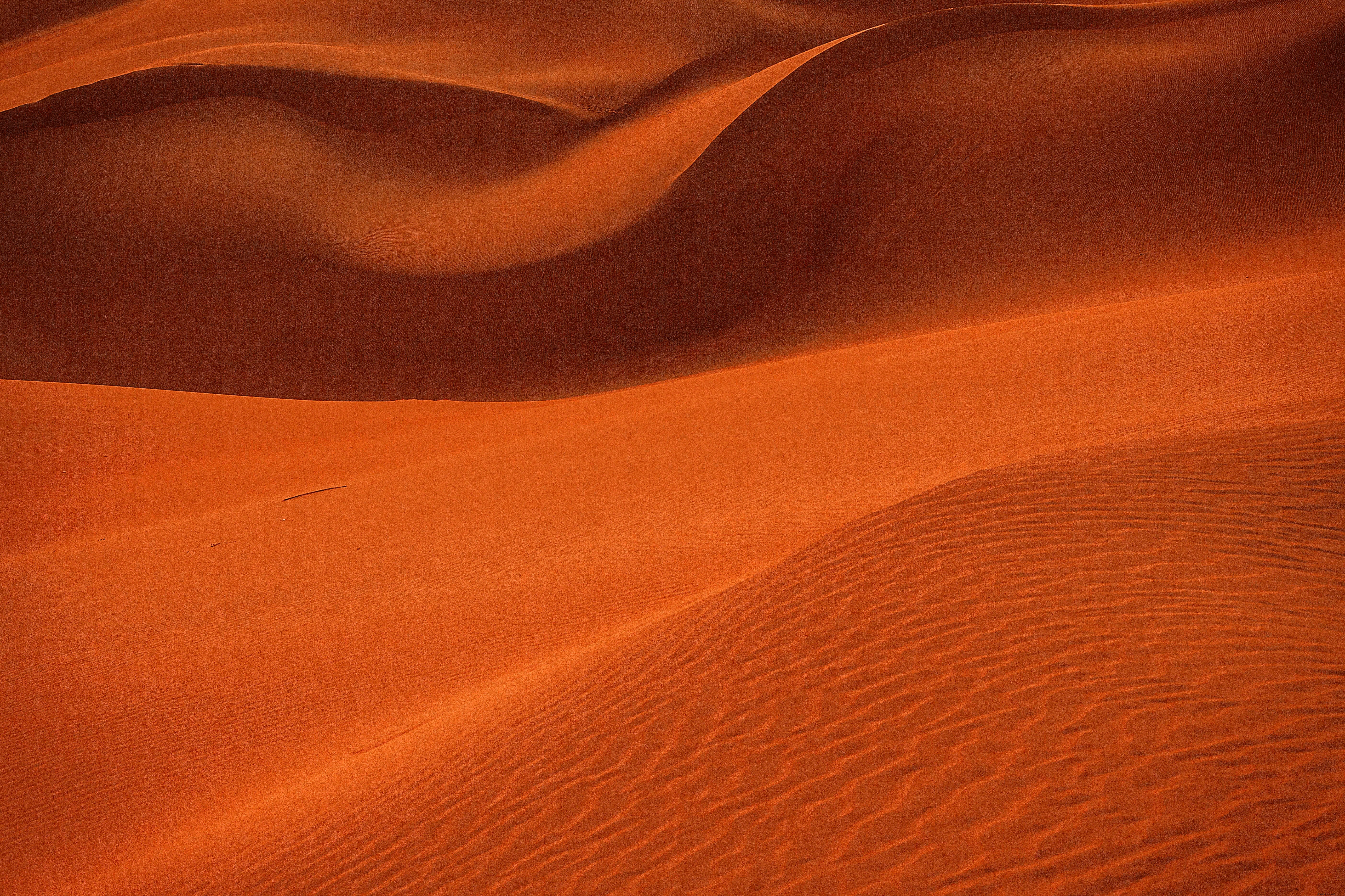Primo piano di dune di sabbia curve arancioni ondulate foto 