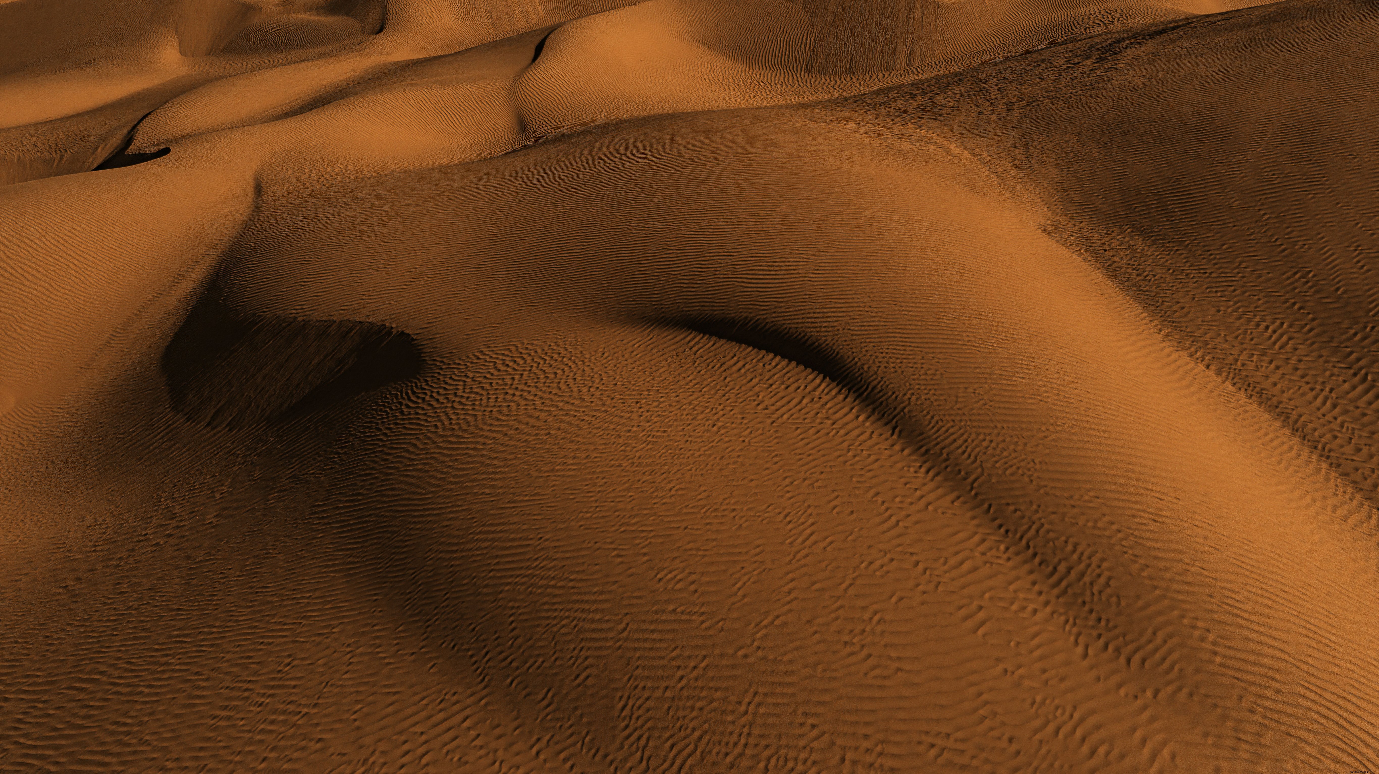 Foto de montanhas de areia laranja vibrante e textura ondulada 
