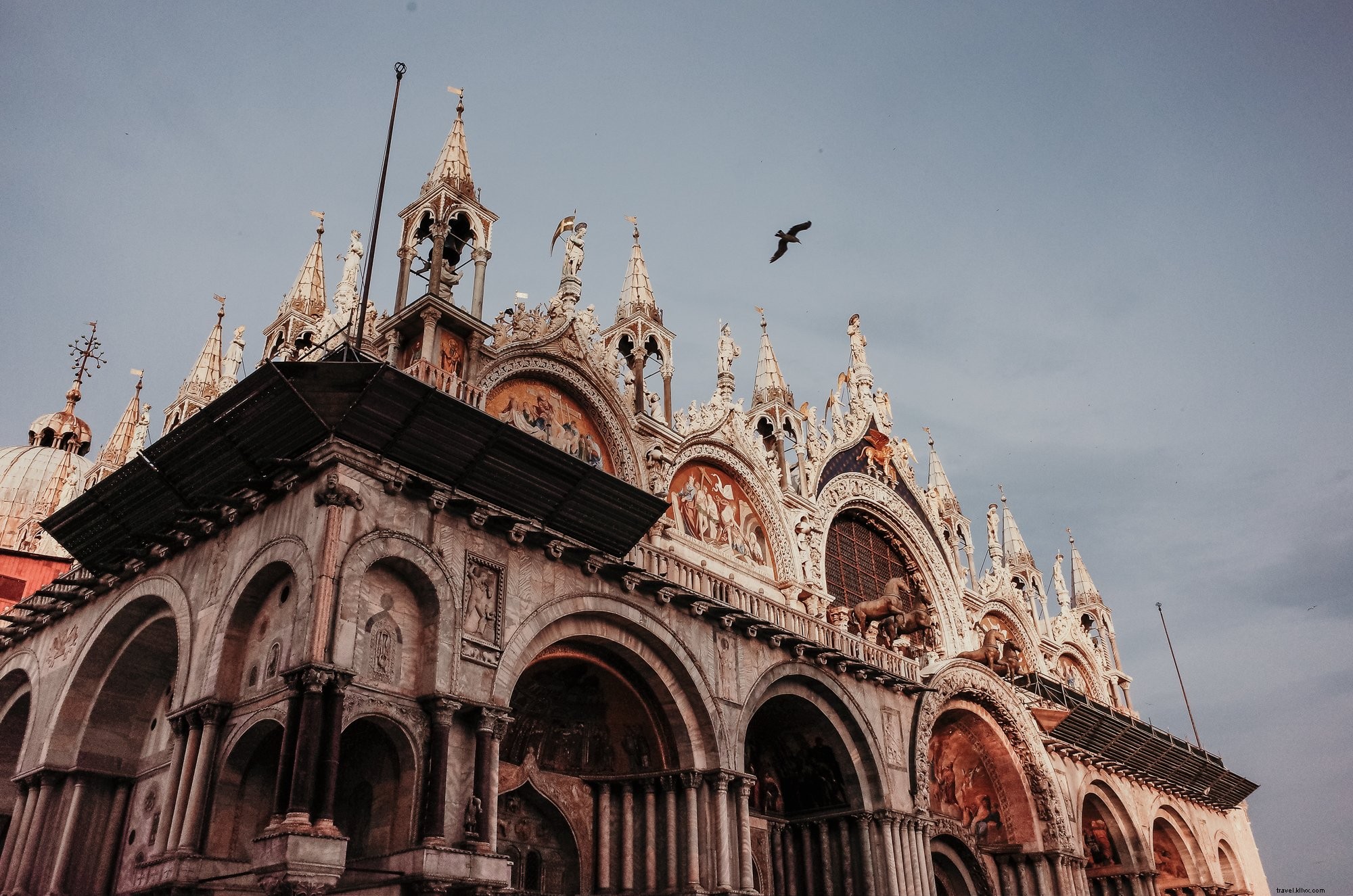 Edifício intrincadamente esculpido com uma foto de pássaro voando no alto 