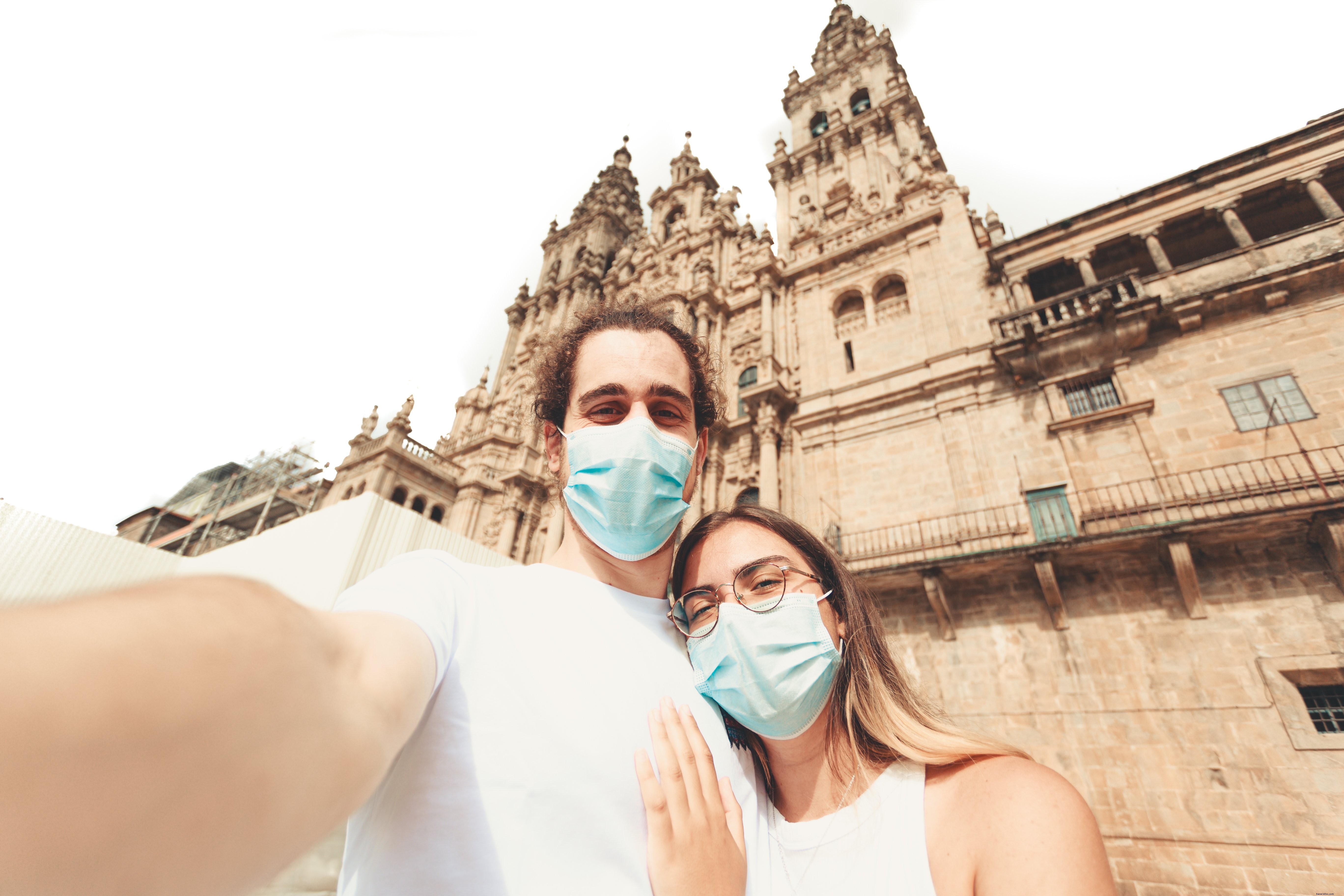 L uomo e la donna indossano maschere per il viso guardando la foto della fotocamera 