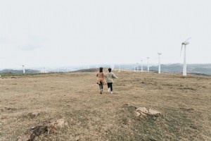 Deux personnes marchent parmi les grands moulins à vent blancs Photo 