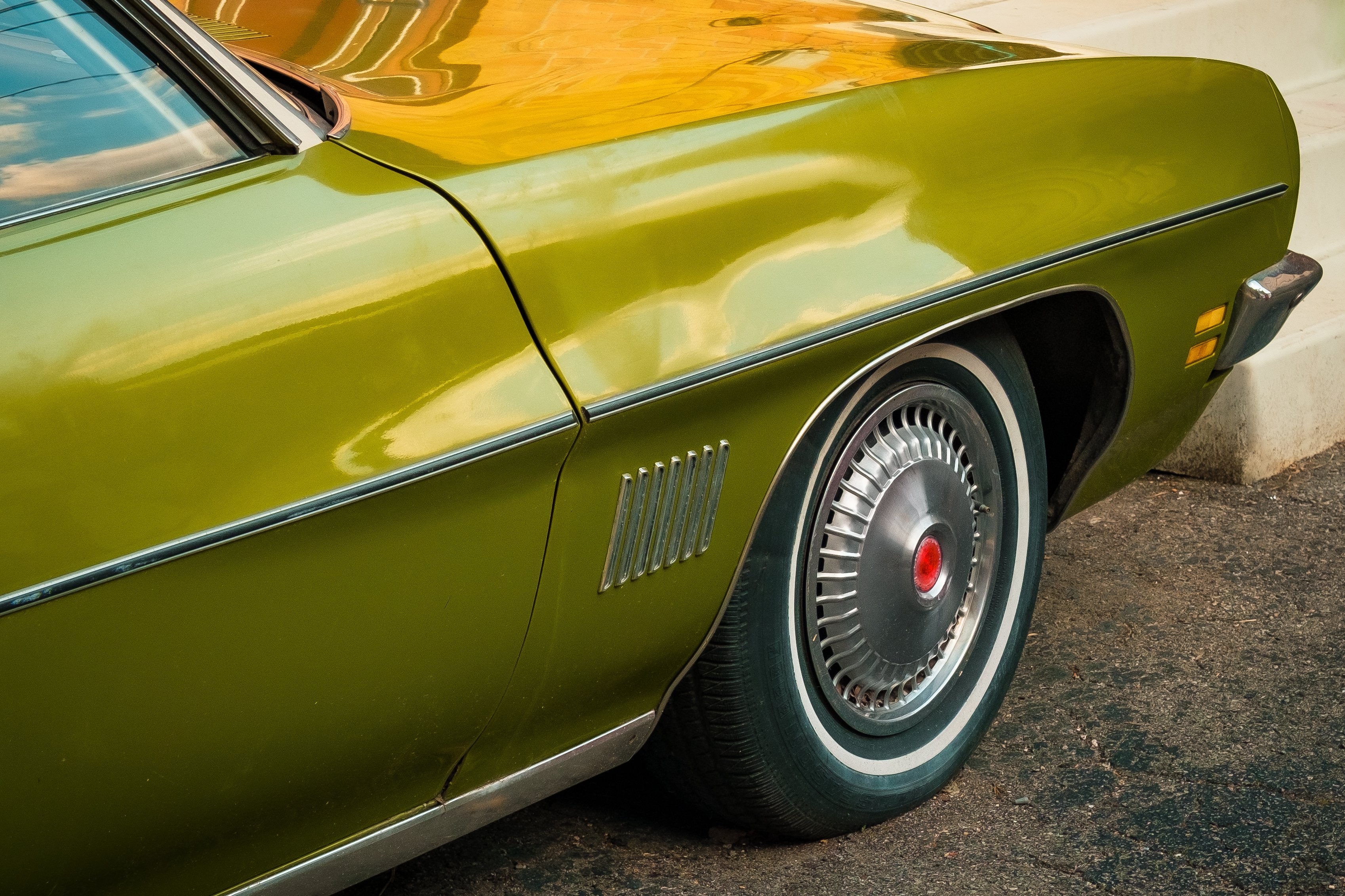 La parte delantera de una foto de coche clásico verde oliva 