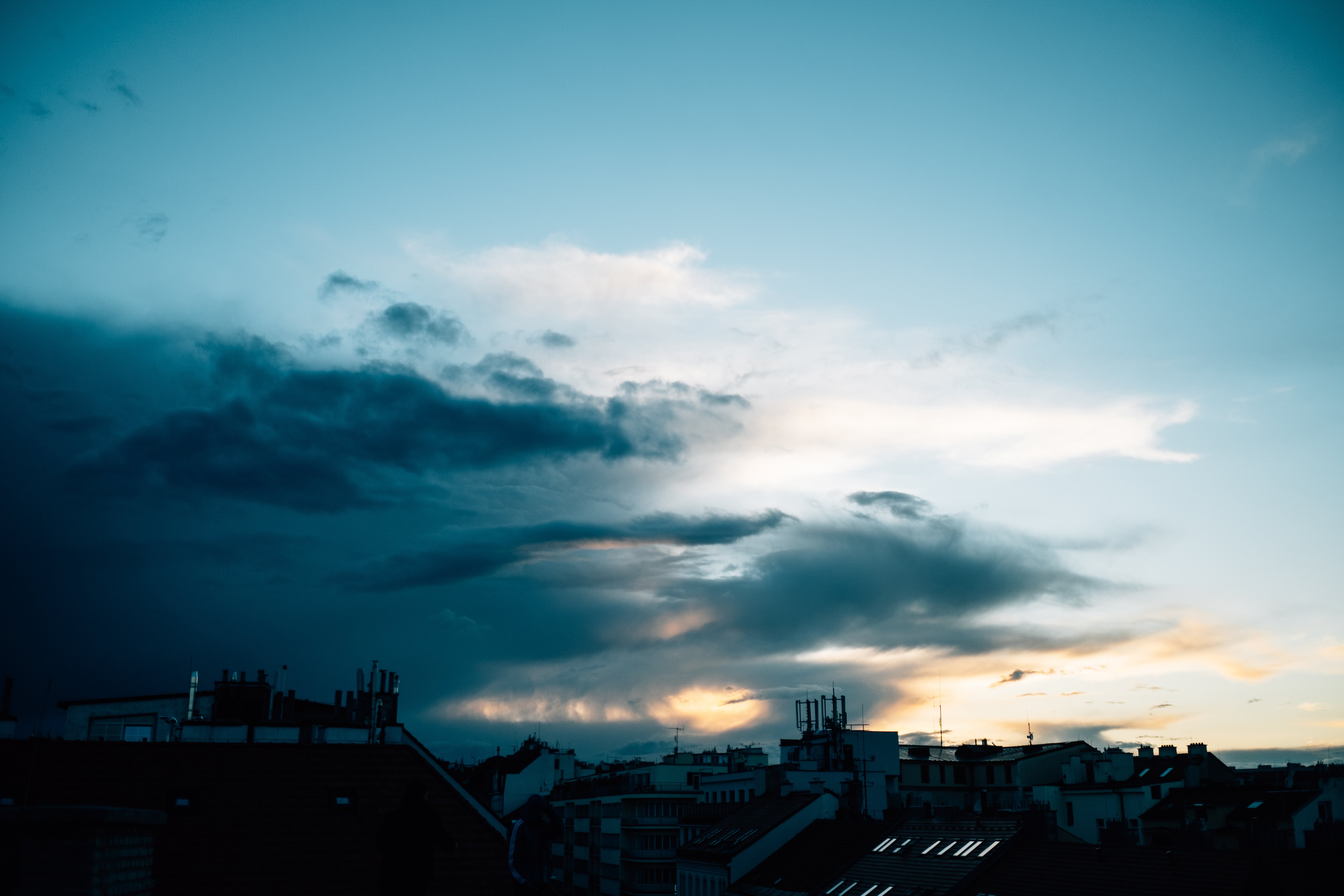 嵐の雲が写真に移動するにつれて都市に沈む夕日 