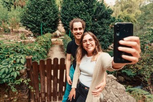 Couple souriant à un téléphone portable en se tenant debout à l extérieur Photo 