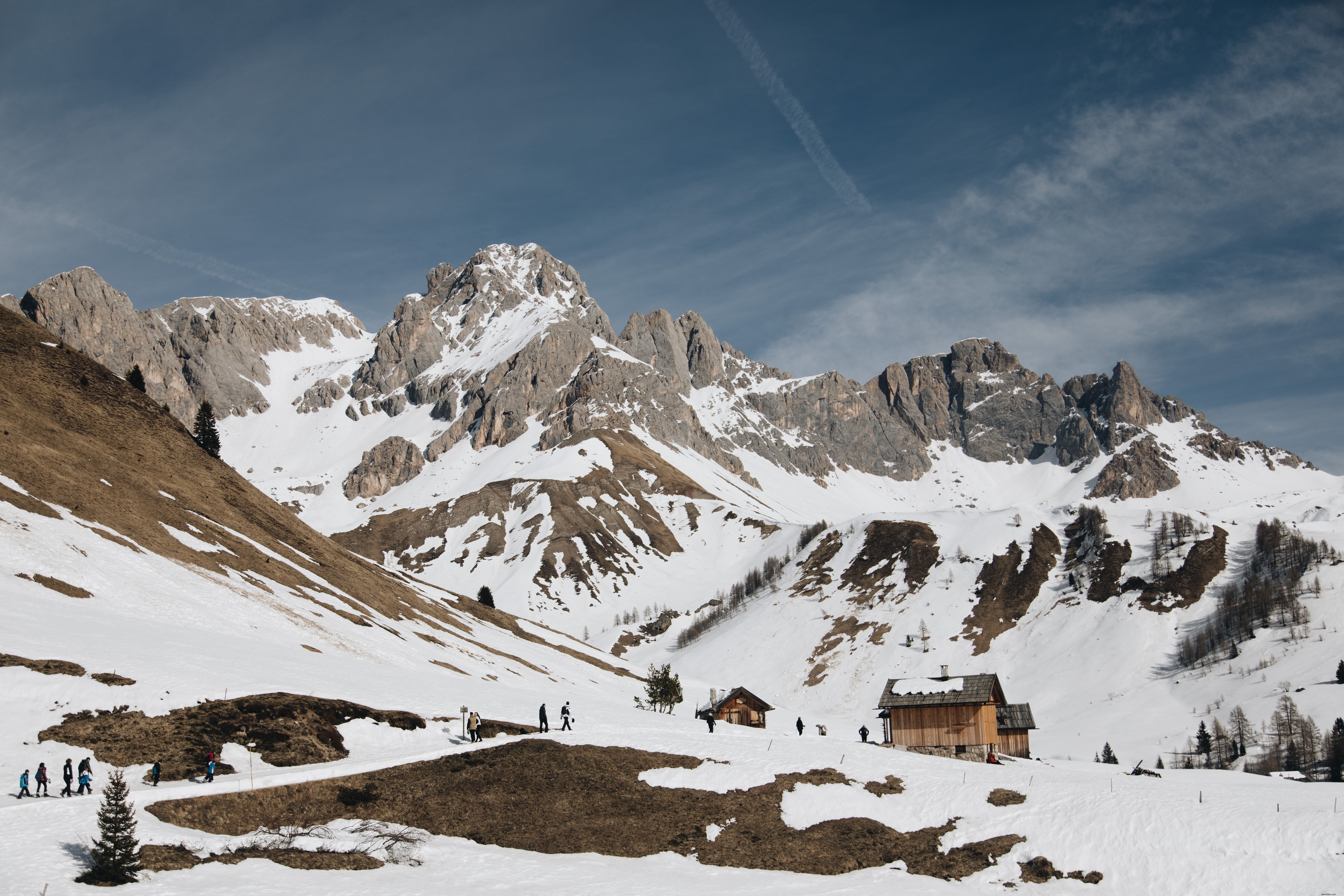 Los turistas regresan a la foto de las cabañas de troncos nevados 