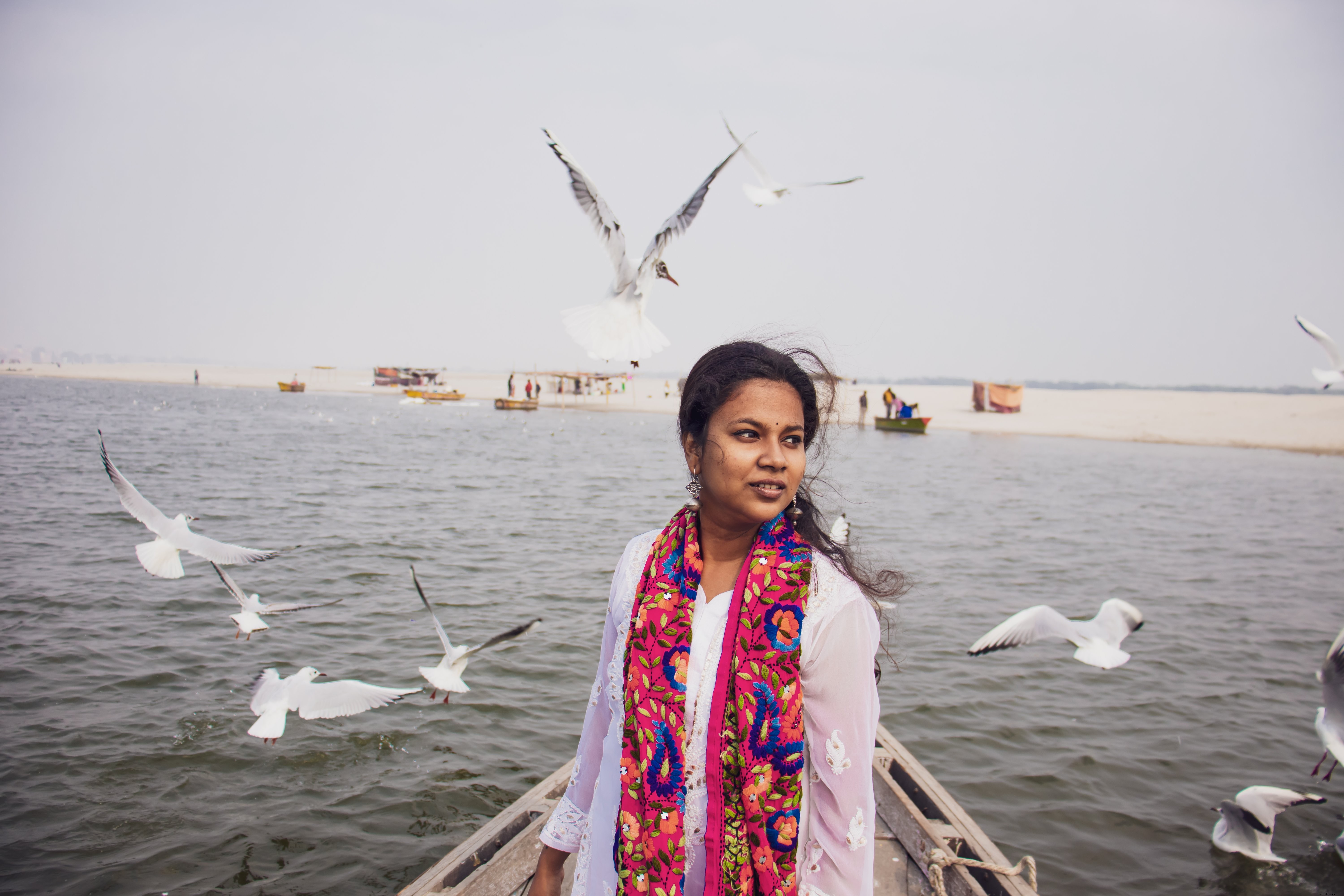 La persona se para en un barco con pájaros a su alrededor Foto 