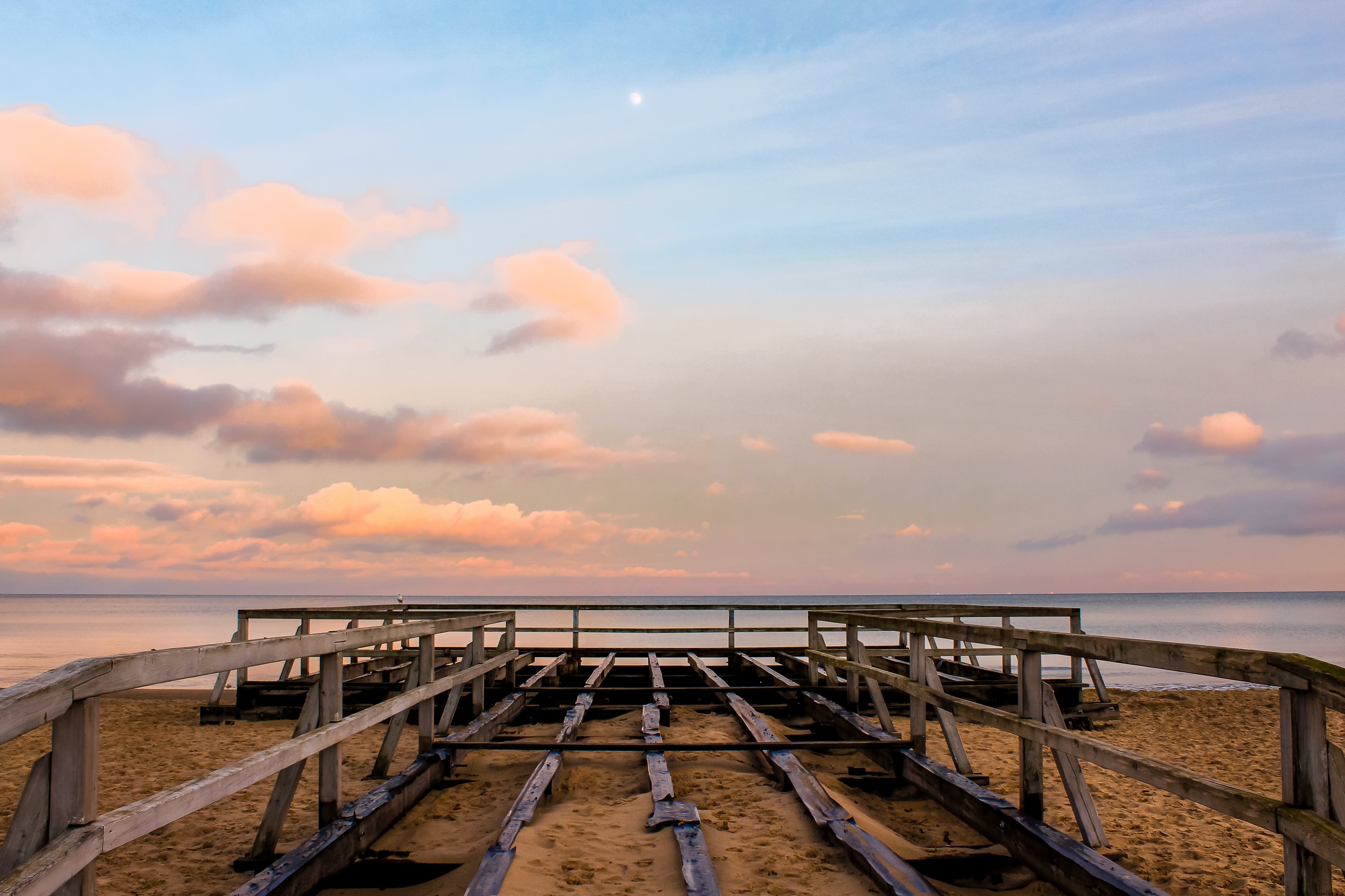 Estructura de madera llegando al agua al atardecer Foto 