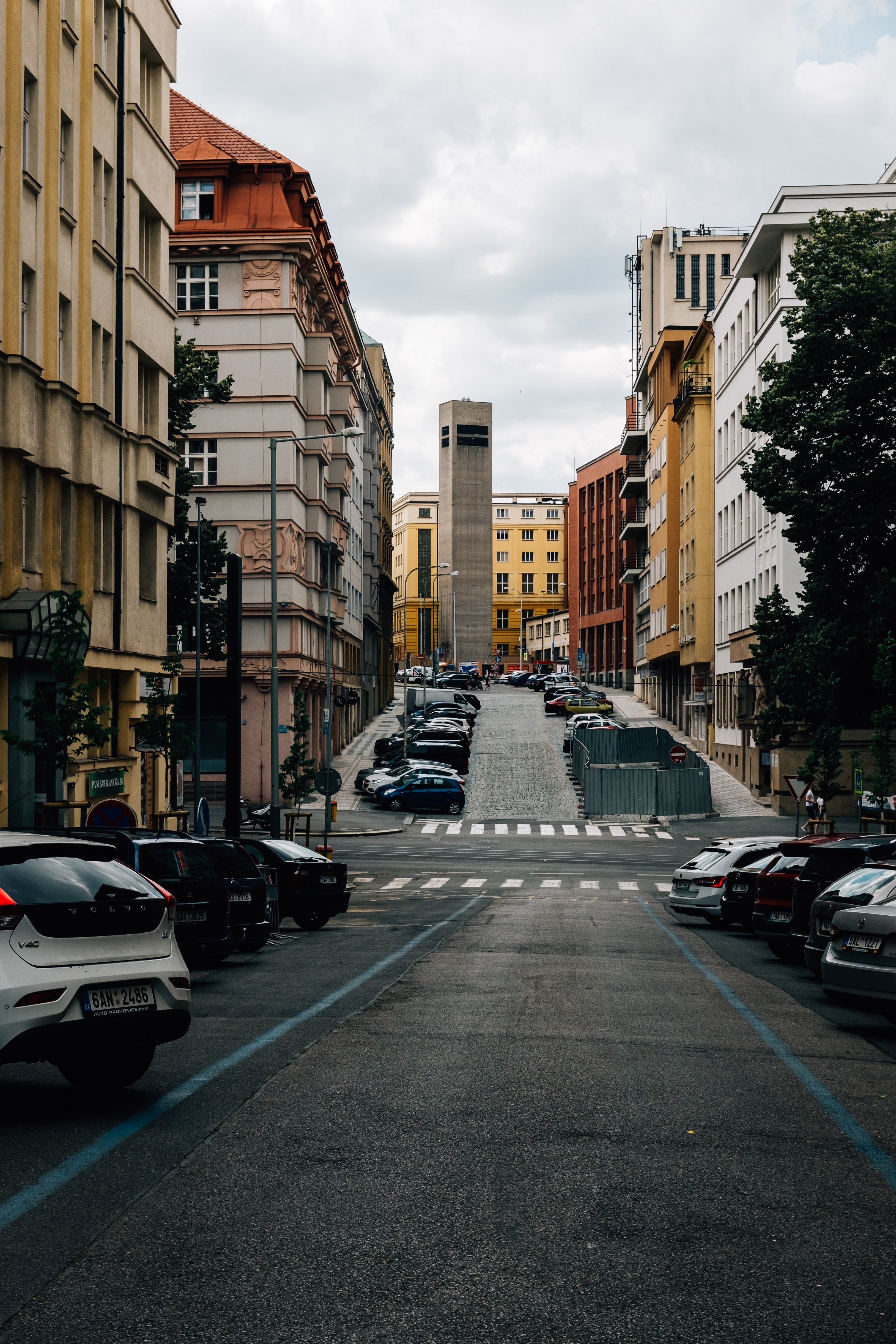 カラフルな建物や駐車中の車が並ぶ静かな街並み写真 