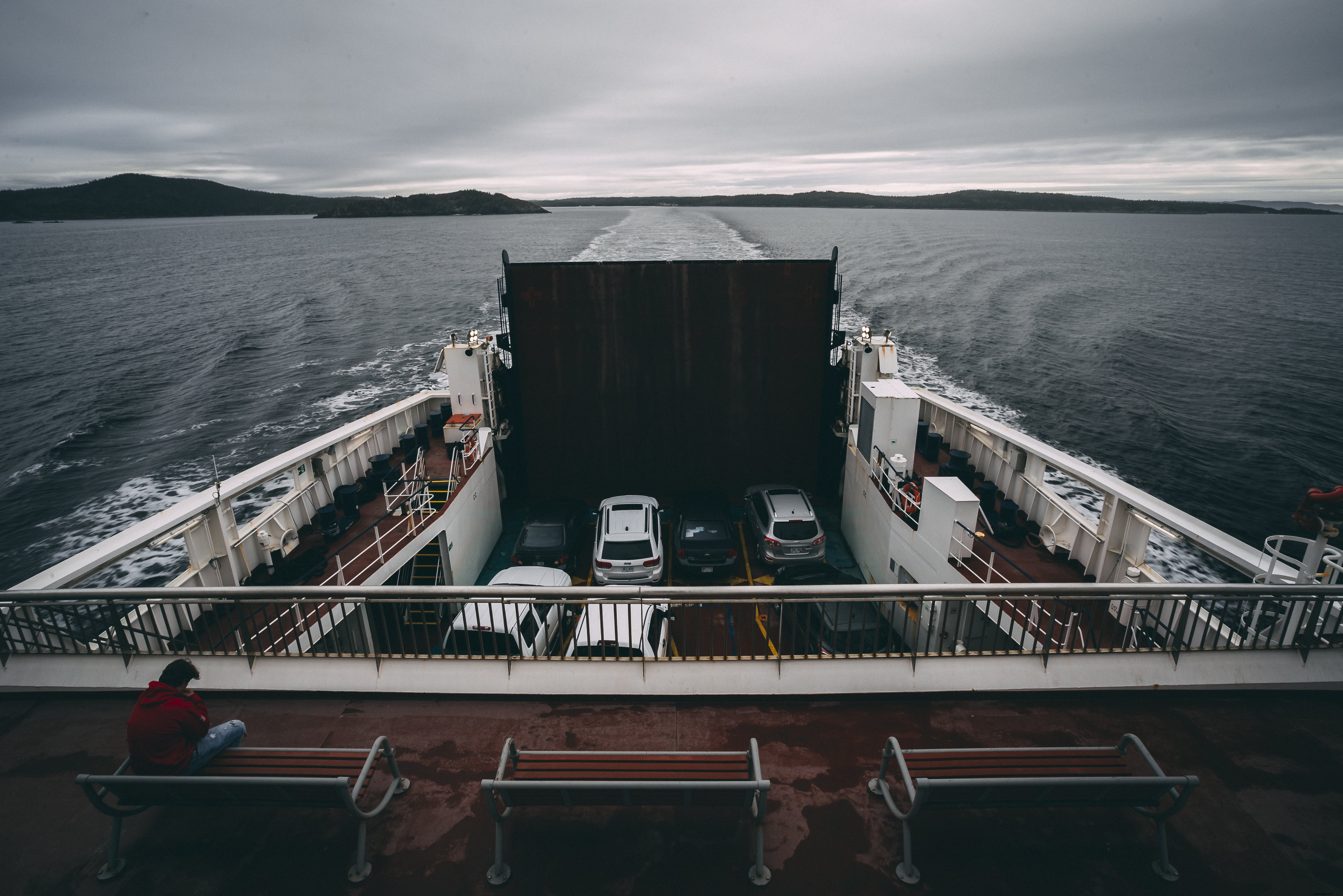 Sentado encima de un ferry viajando por el agua Foto 