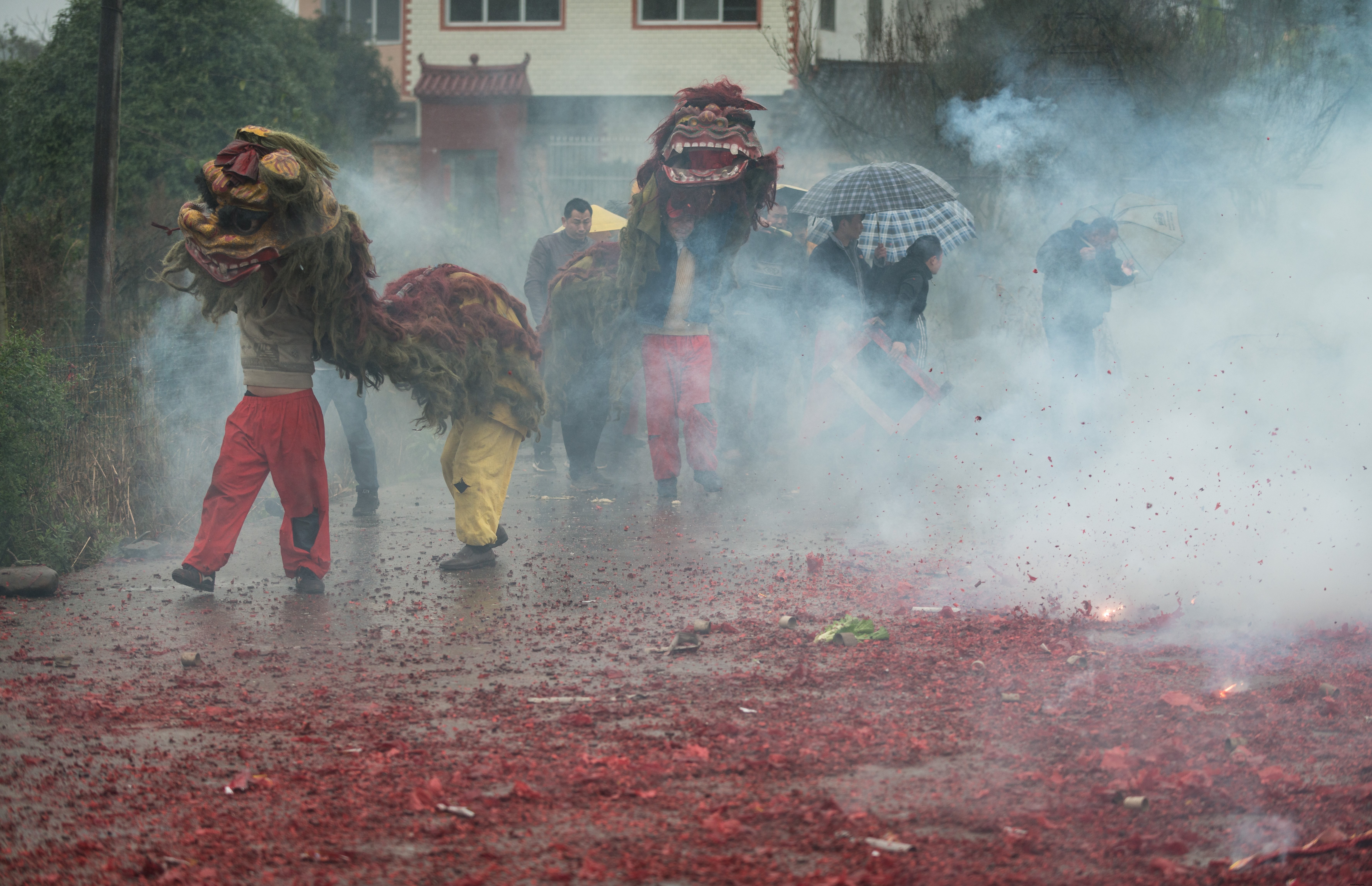 布ドラゴンの写真で霧の街を歩いている人々 