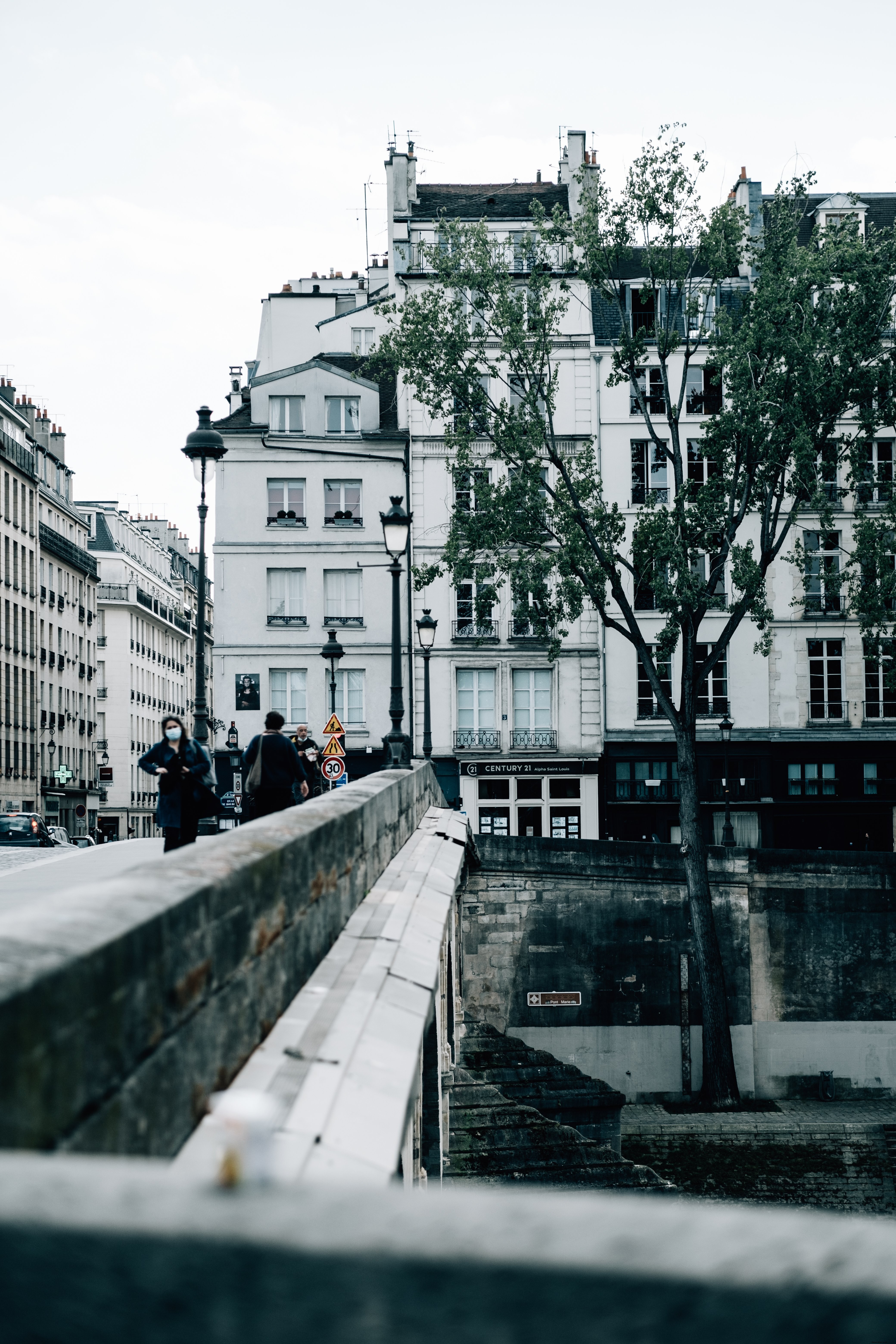 Les gens marchent sur un pont de pierre près des bâtiments Photo 