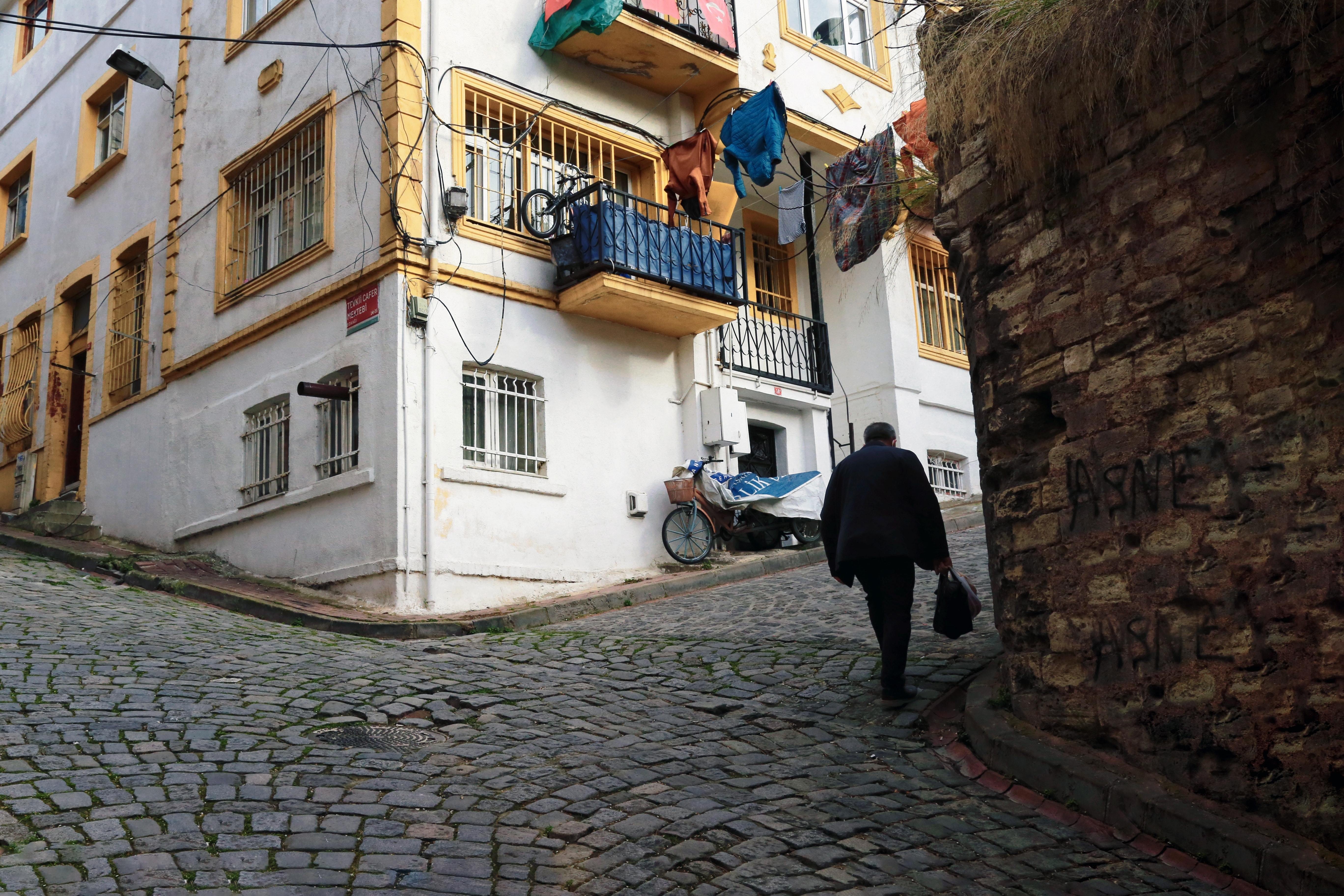 Camminando su una strada di ciottoli da un edificio bianco e giallo foto 