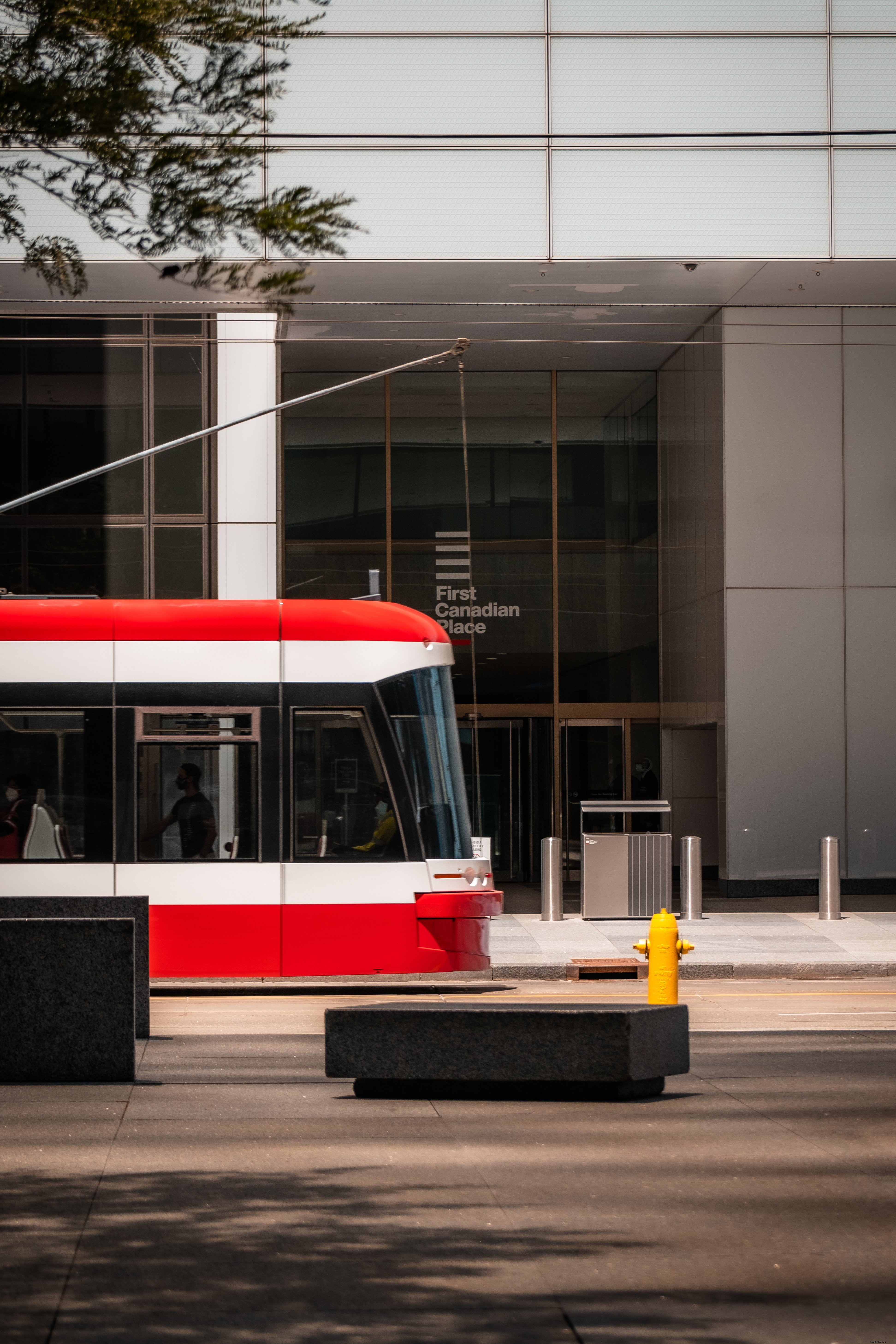 Lato di un edificio di vetro con un tram rosso foto 